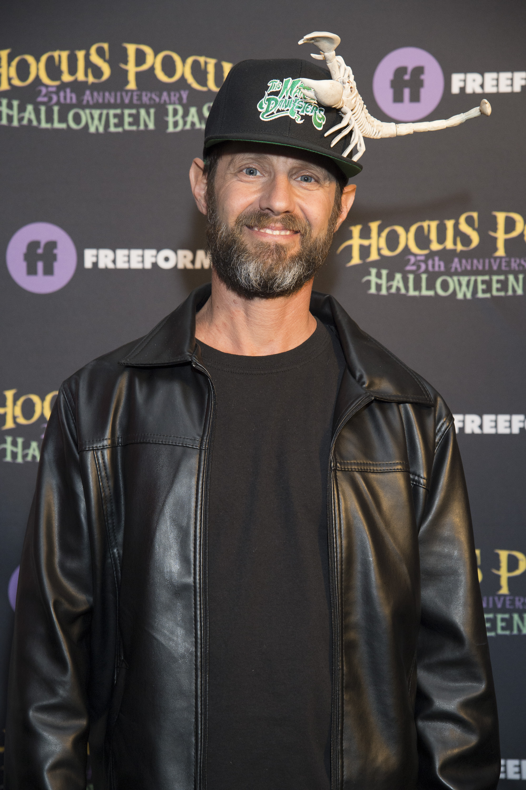 Fully grown, Omri Katz sports a rugged, mature adult look with a salt-and-pepper beard, trimmed mustache, and a black leather jacket over a black shirt, a stark contrast to the clean-shaven, fresh-faced appearance of his teen heartthrob years. He topped the look with a black baseball cap featuring a decorative scorpion skeleton during Freeform's "Hocus Pocus 25th Anniversary Halloween Bash", filmed at the Hollywood Forever Cemetery in October 2018.