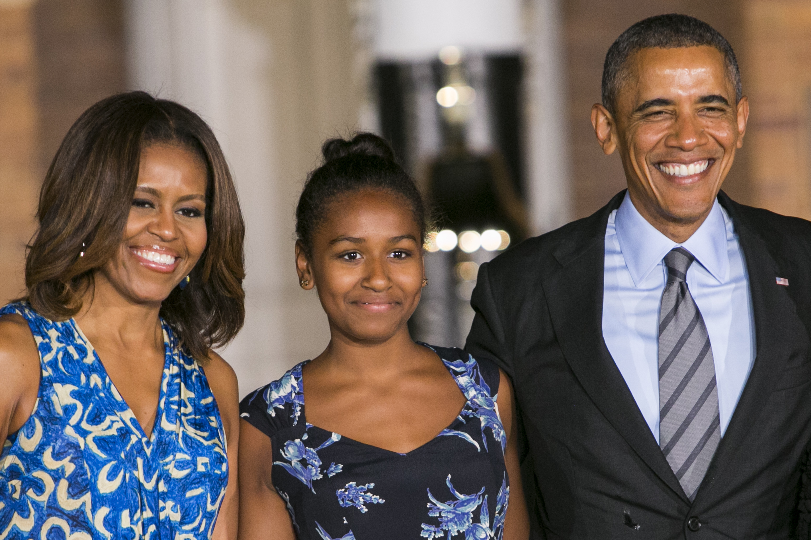 At the Marine Barracks Evening Parade on June 27, 2014, in Washington, D.C., Sasha Obama, dressed in a dark floral print dress, stood with her parents, President Barack Obama and First Lady Michelle Obama, for the long-standing military tradition.