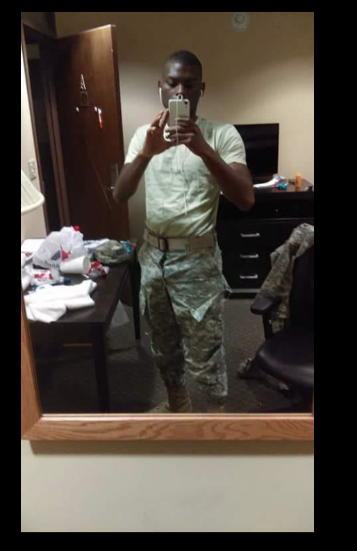 A mirror selfie of Shamar Elkins shows him standing in a modest room, dressed in military uniform as he captures the moment on his phone. | Source: Facebook/Crime Stories