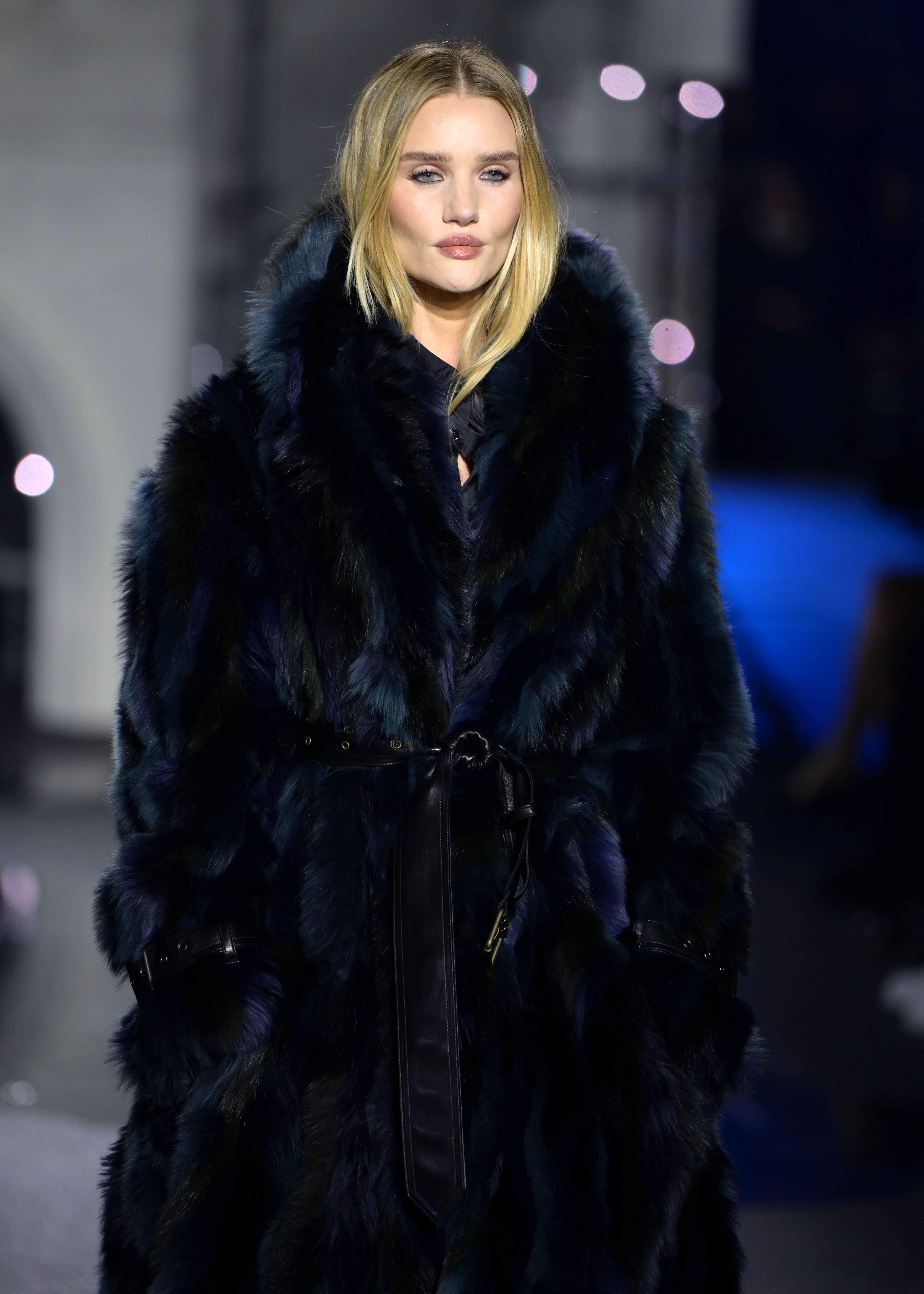 Rosie Huntington-Whiteley commands the runway at a Burberry show, wrapped in a dramatic inky fur coat cinched at the waist with a sleek leather belt. | Source: Getty Images