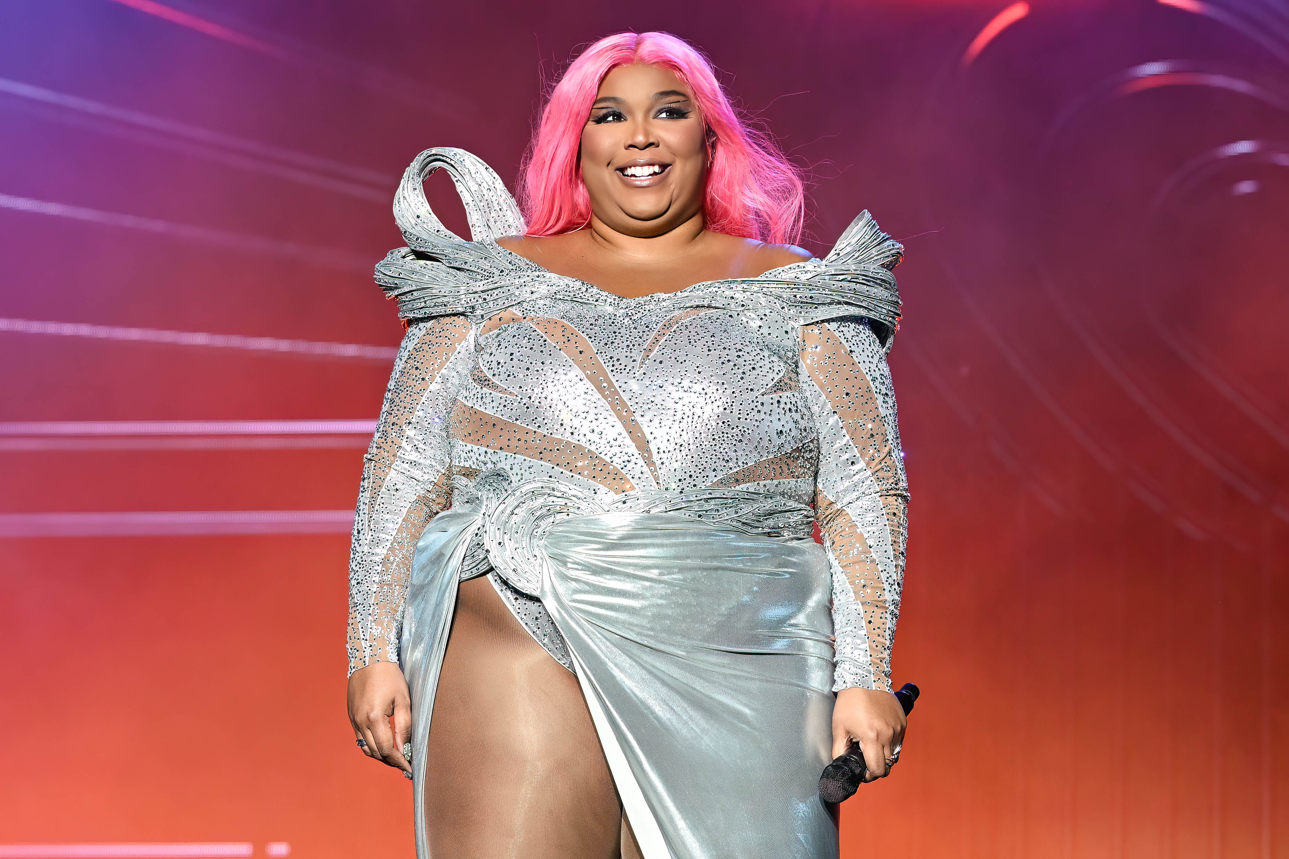 At Governors Ball in June, Lizzo took the stage in a sculpted silver gown with sheer mesh panels and crystal embellishments, drawing attention to her fuller upper body and visible double chin.