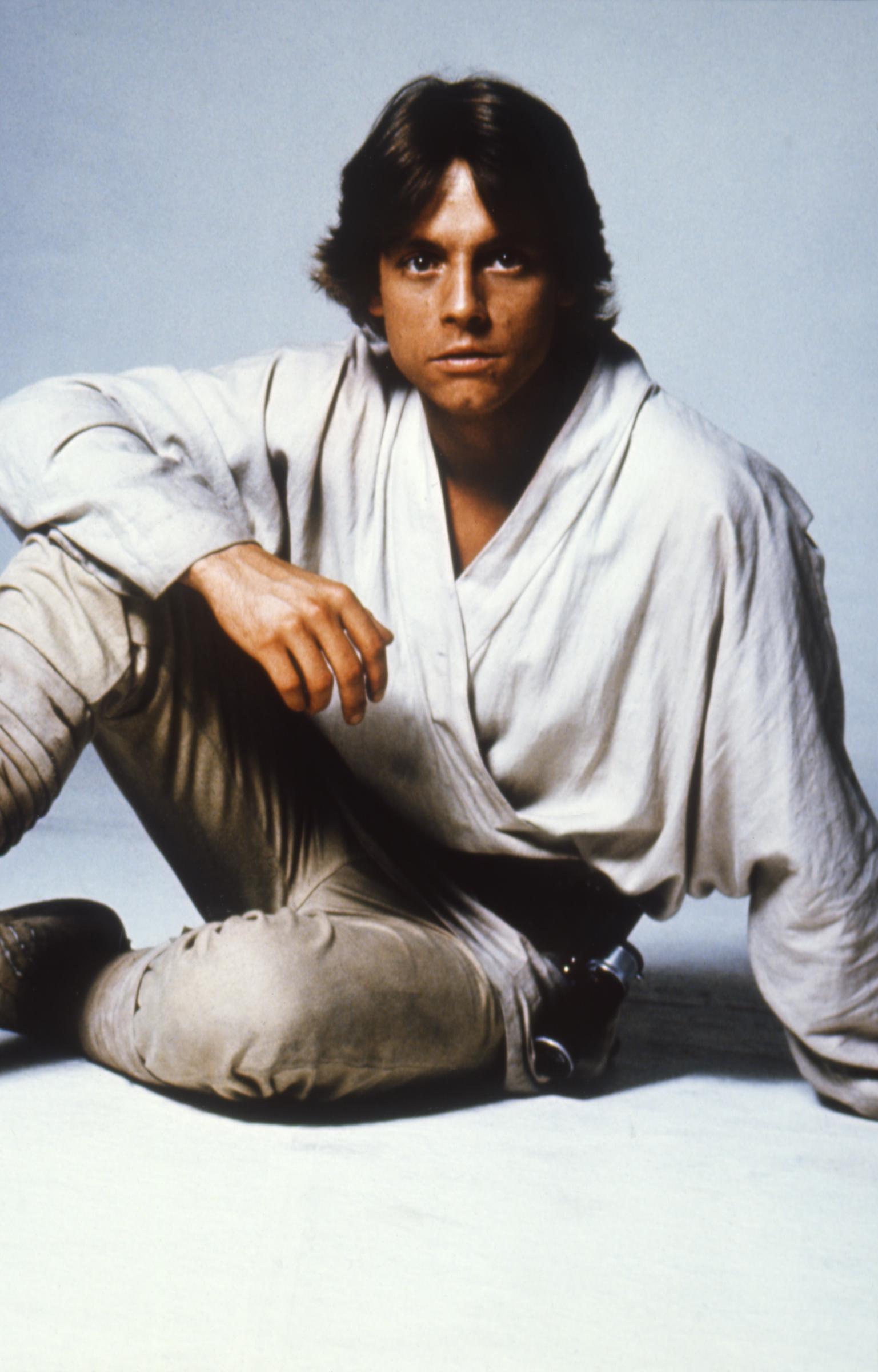 Mark Hamill posed in character as Luke Skywalker for "Star Wars: A New Hope," wearing the simple, light-colored costume that became synonymous with the young hero's introduction. The portrait captured Hamill's appearance before the January 11, 1977, car crash that fractured his nose and left cheekbone. By the time the film opened on May 25, 1977, Hamill's performance had propelled the previously little-known actor to international fame.