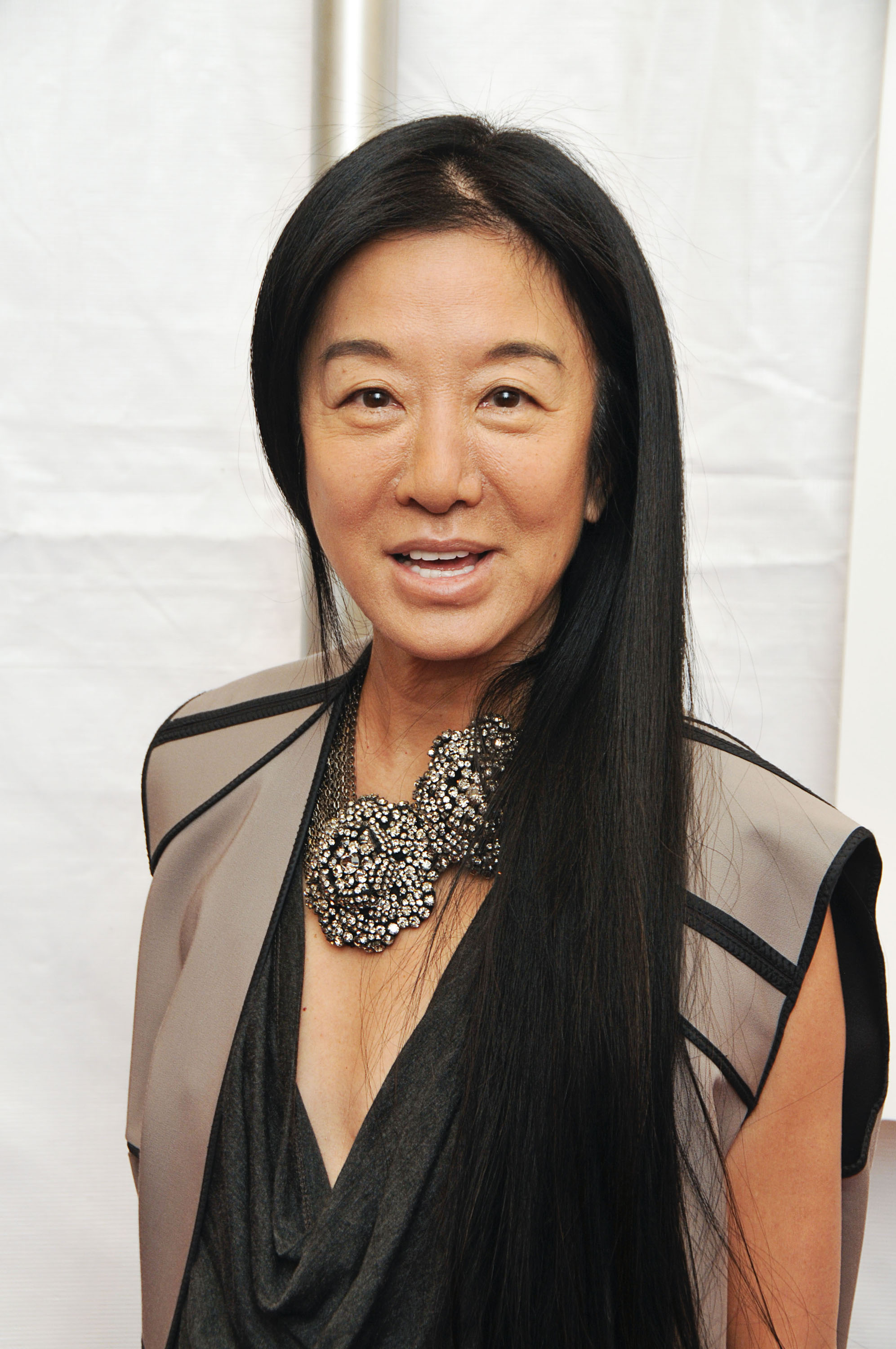 Vera Wang attended the premiere of "City Island" at The Directors Guild of America Theater on March 10, 2010, in New York City. The fashion icon wore a draped charcoal top layered under a structured taupe vest with black piping, finishing the look with a dramatic clustered crystal statement necklace and her pin-straight dark hair cascading down one side. | Source: Getty Images