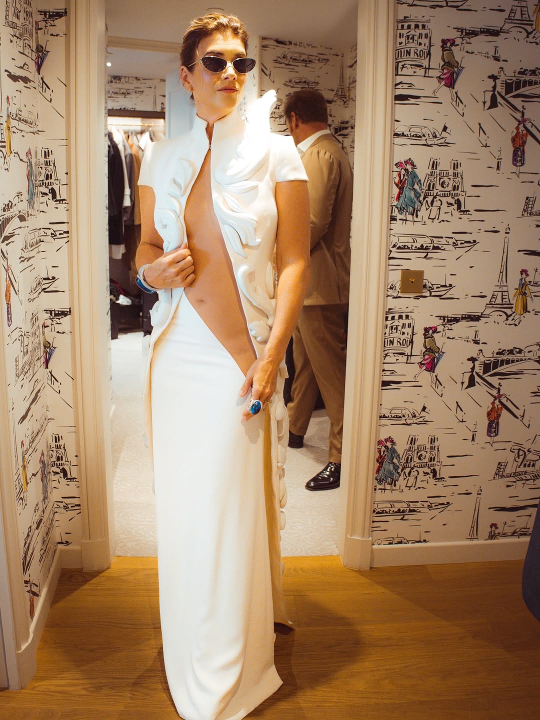 Kate Walsh stands in a room wearing the daring white dress moments before stepping out | Source: Instagram/katewalsh