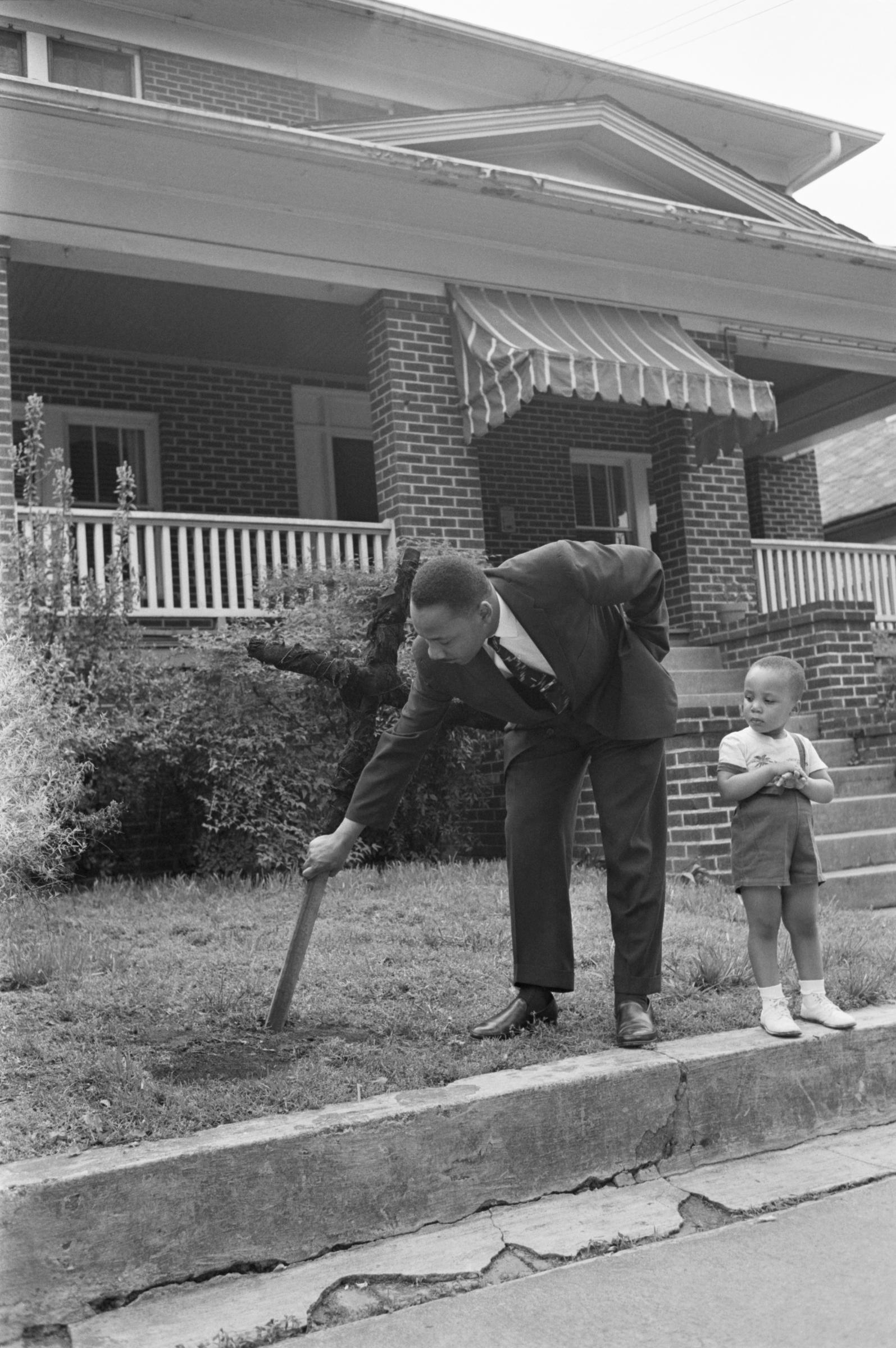 Dr. King removing a burnt cross as his son looks on | Source: Getty Images