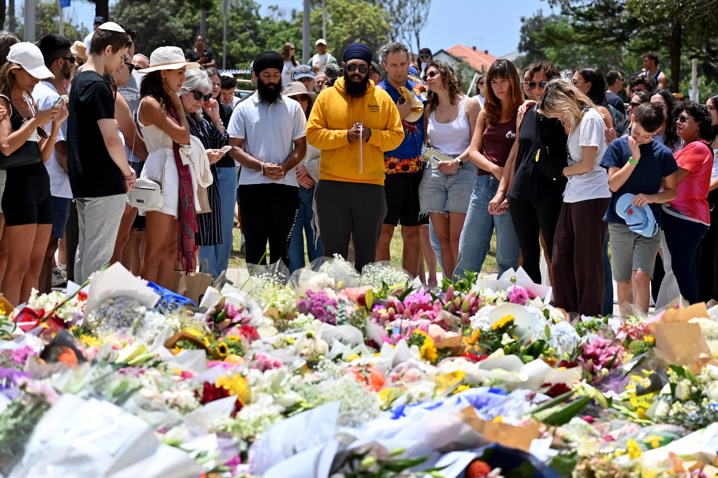 Mourners gather by floral tributes at the Bondi Pavillion in memory of the victims at Bondi Beach, in Sydney on December 15, 2025. | Source: Getty Images