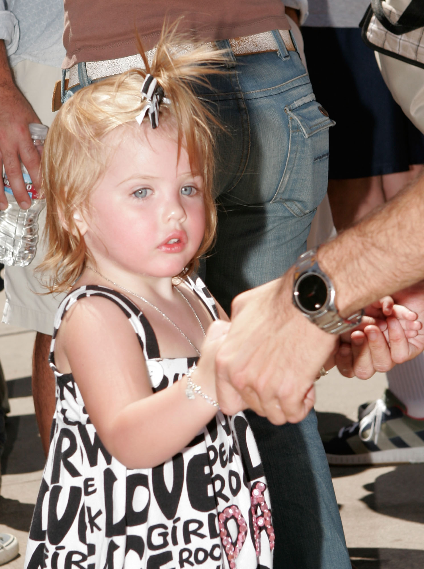 Holding tightly to her father Larry's hand at Universal Studios on May 17, 2008, 20-month-old Dannielynn Birkhead made an adorable public appearance at the launch of "The Simpsons Ride". Sporting a playful black-and-white graphic dress accented with pink glitter lettering and a tiny topknot ribbon, her wide, curious blue eyes and soft porcelain features captured the sheer wonder of toddlerhood.
