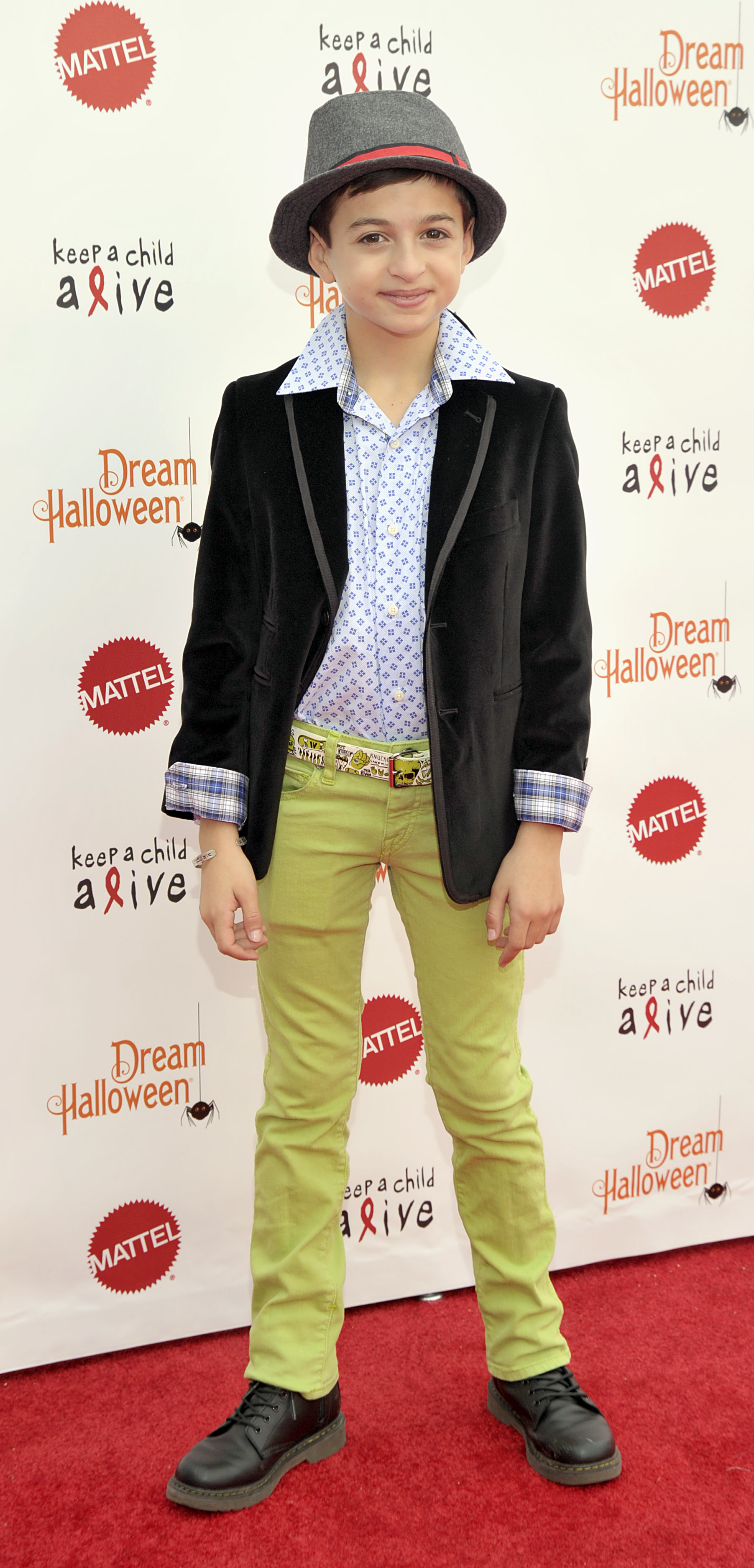 She attends Keep a Child Alive's 20th Annual Dream Halloween event at the Barker Hangar in Santa Monica, California, wearing a gray fedora, a black blazer, a patterned blue shirt, bright green trousers, and black boots. | Source: Getty Images