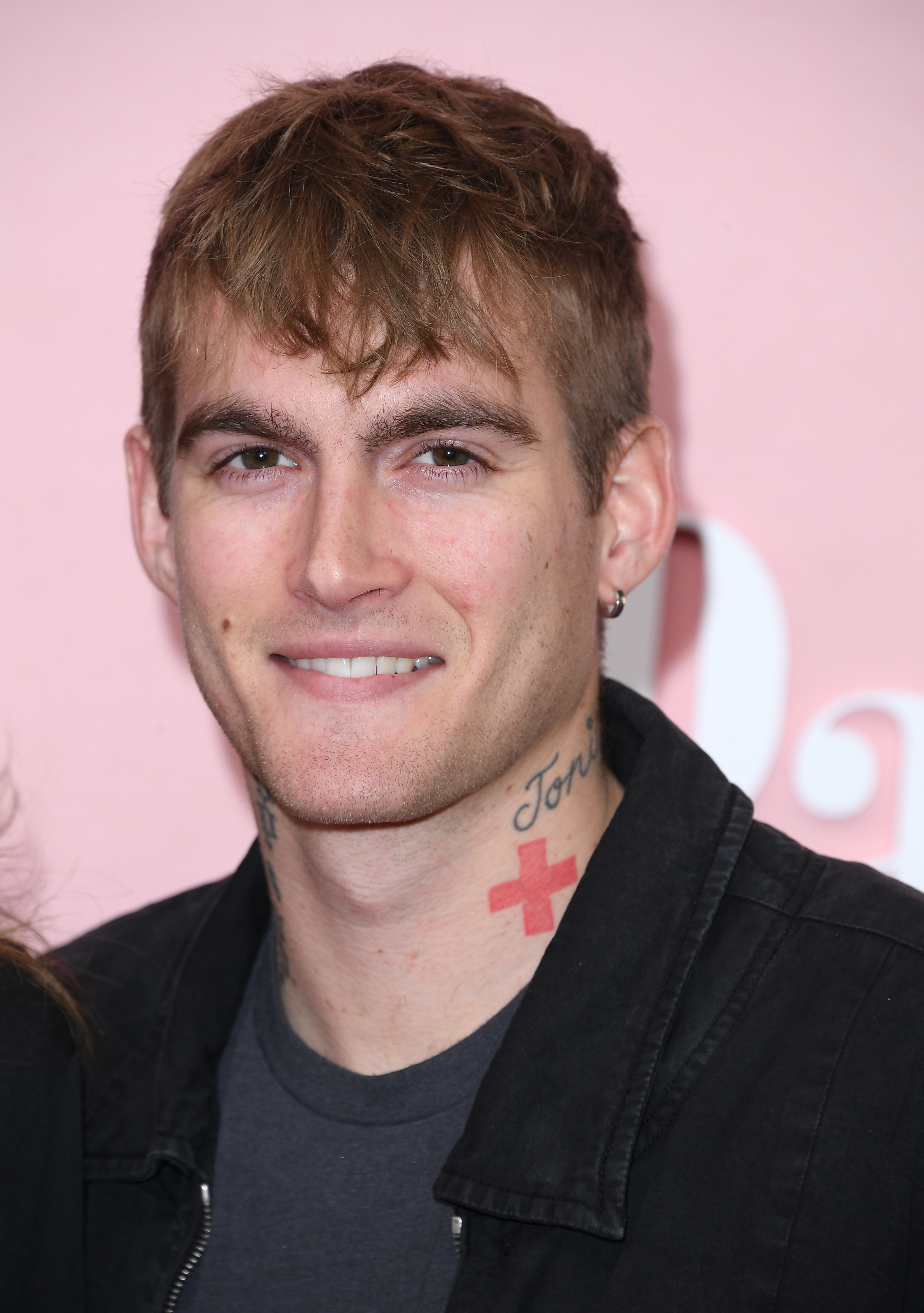 Presley Gerber flashed a relaxed smile at the world premiere of "Palm Royale" on March 14, 2024, at the Samuel Goldwyn Theater in Beverly Hills, California. Opting for a casual edge, he paired a black jacket over a dark gray tee, putting his distinct neck tattoos and a silver hoop earring on display. | Source: Getty Images