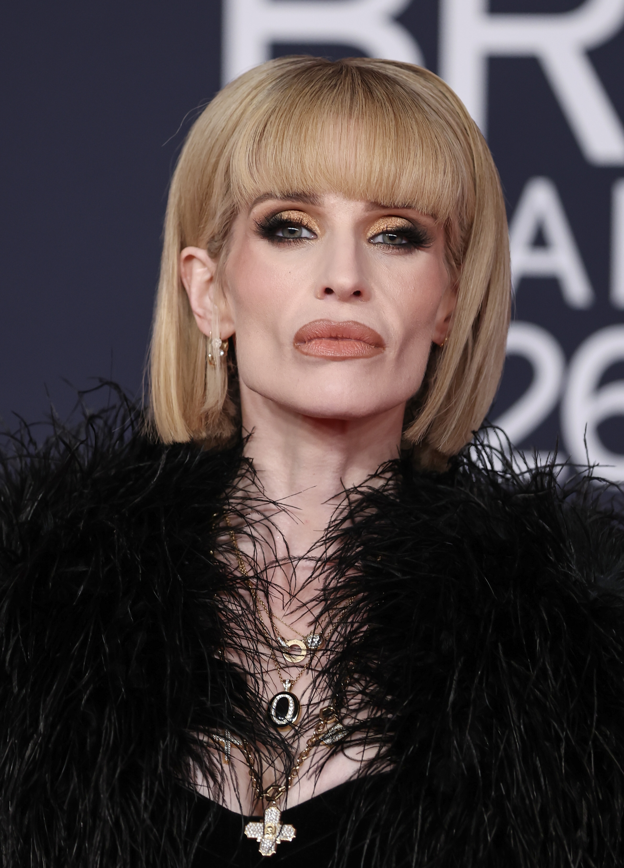 Kelly Osbourne attends The BRIT Awards 2026 at Co-op Live in Manchester, wearing a black feather-trimmed look and a sleek blonde bob with bangs. | Source: Getty Images