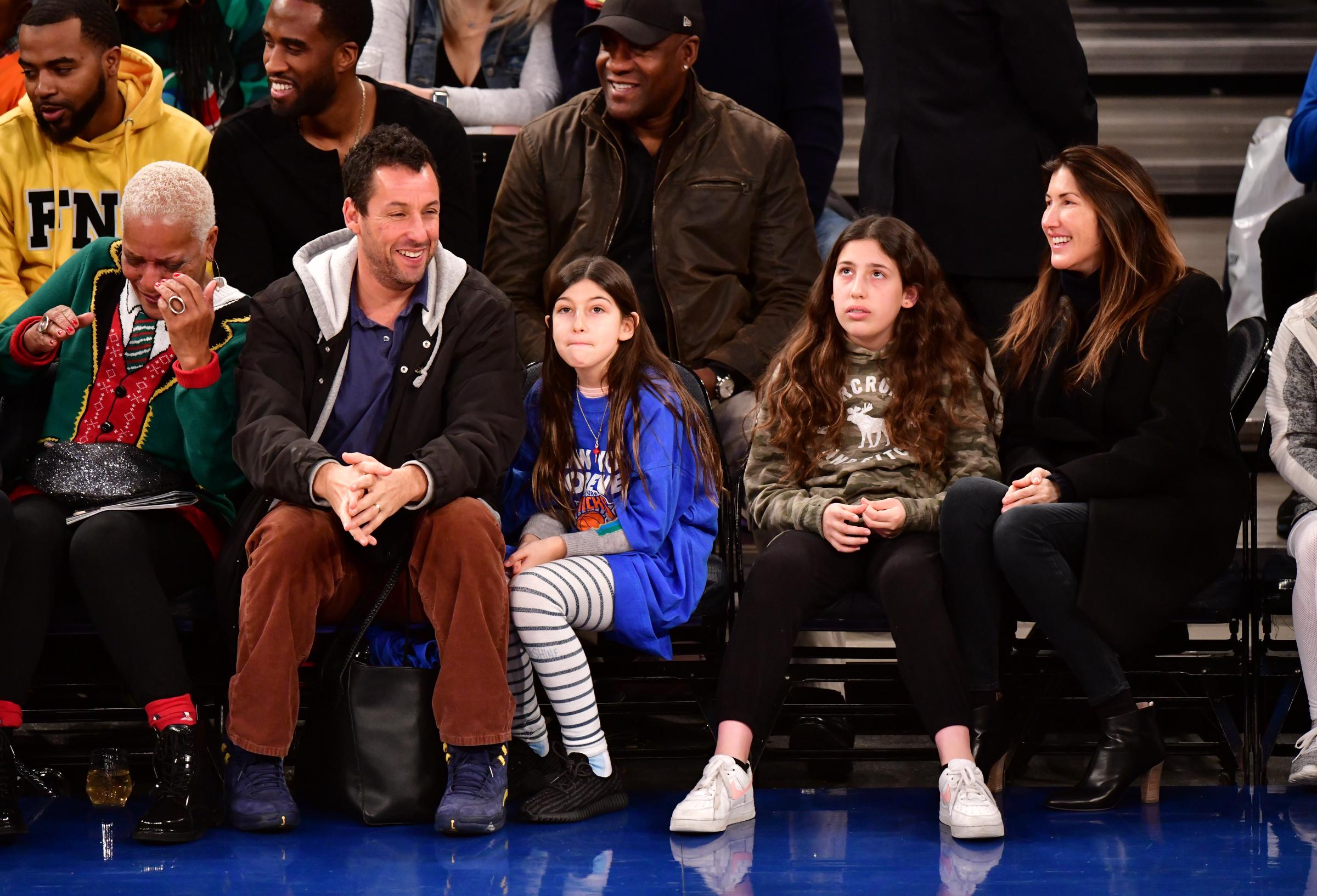 Adam and Jackie Sandler, pictured with daughters Sunny and Sadie at a New York Knicks game in 2018, have drawn attention over the years for their close family appearances. | Source: Getty Images
