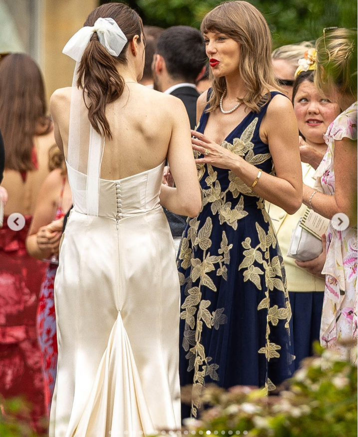 Taylor Swift chats with the bride, Laura Sisk, at her wedding in Gloucestershire, England, showcasing her new side-swept bangs and shoulder-length hairstyle. | Source: Instagram/deuxmoi
