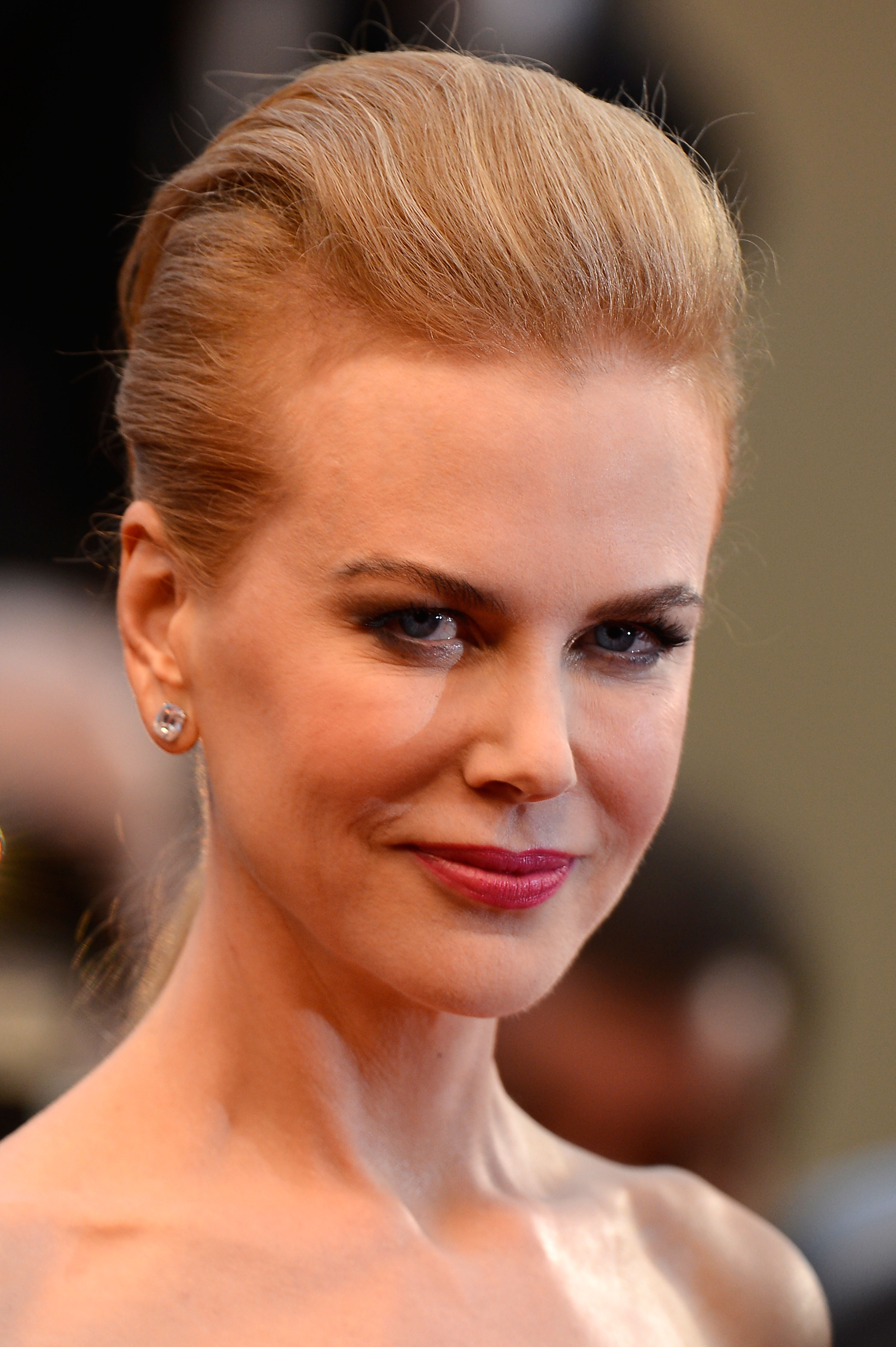 Sporting an edgy, high-volume pompadour updo at "The Great Gatsby" Cannes premiere in May 2013, her styling opted for a sharp, high-fashion vibe. With her hair pulled completely back, her face showed a return to natural expressions, featuring visible crinkling around the eyes and a relaxed, unforced smile. | Source: Getty Images