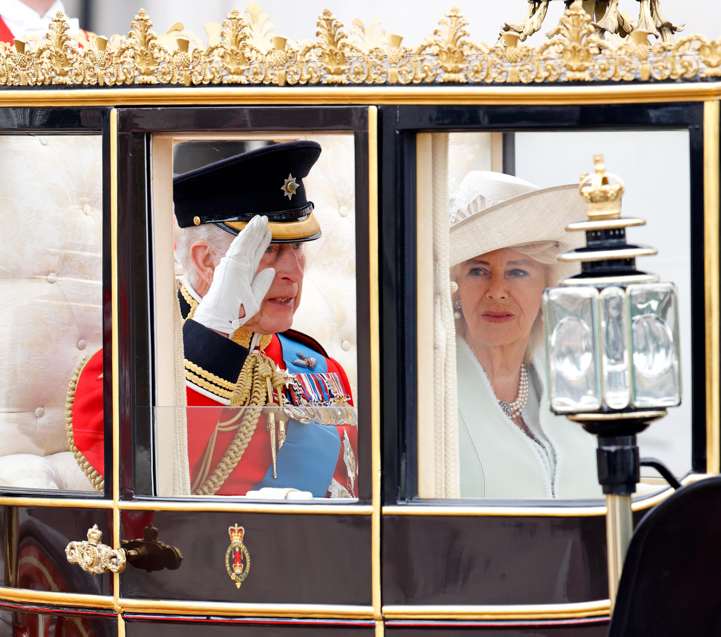 King Charles III salutes in the Scottish State Coach alongside Queen Camilla as they depart Buckingham Palace en route to Horse Guards Parade on June 15, 2024 | Source: Getty Images