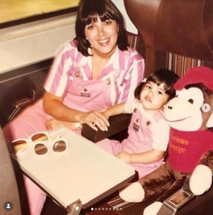 A young Kris Jenner poses with daughter Kourtney Kardashian during a throwback family moment, both dressed in matching pink outfits as they sit beside a large stuffed toy. | Source: Instagram/krisjenner