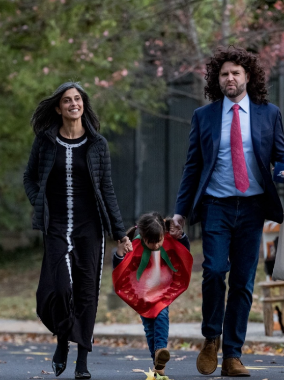 JD Vance and Usha walk outdoors holding hands with one of their children, who is dressed in a red costume, as they move along a tree-lined path. | Source: Instagram/vp