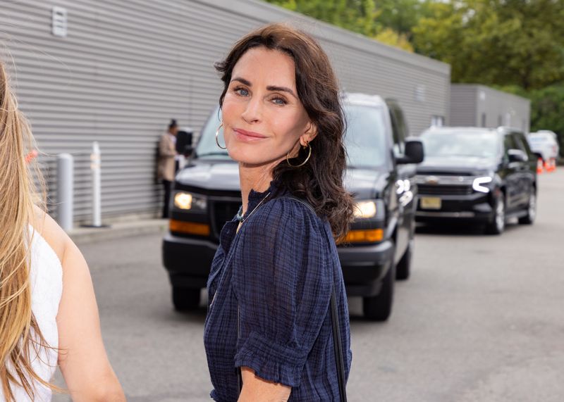 Courteney Cox keeps it casual in a blue linen shirt and natural makeup while attending the Women's Singles Final at the US Open on September 7, 2024, in New York City.