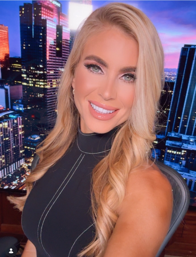 Katie Zacharia poses for a photo in a black sleeveless top against a backdrop of city skyscrapers at dusk. She has remained connected to Pepperdine University through her work with its law school and other university roles, even as her career has expanded into political communications. | Source: Instagram/katiezacharia