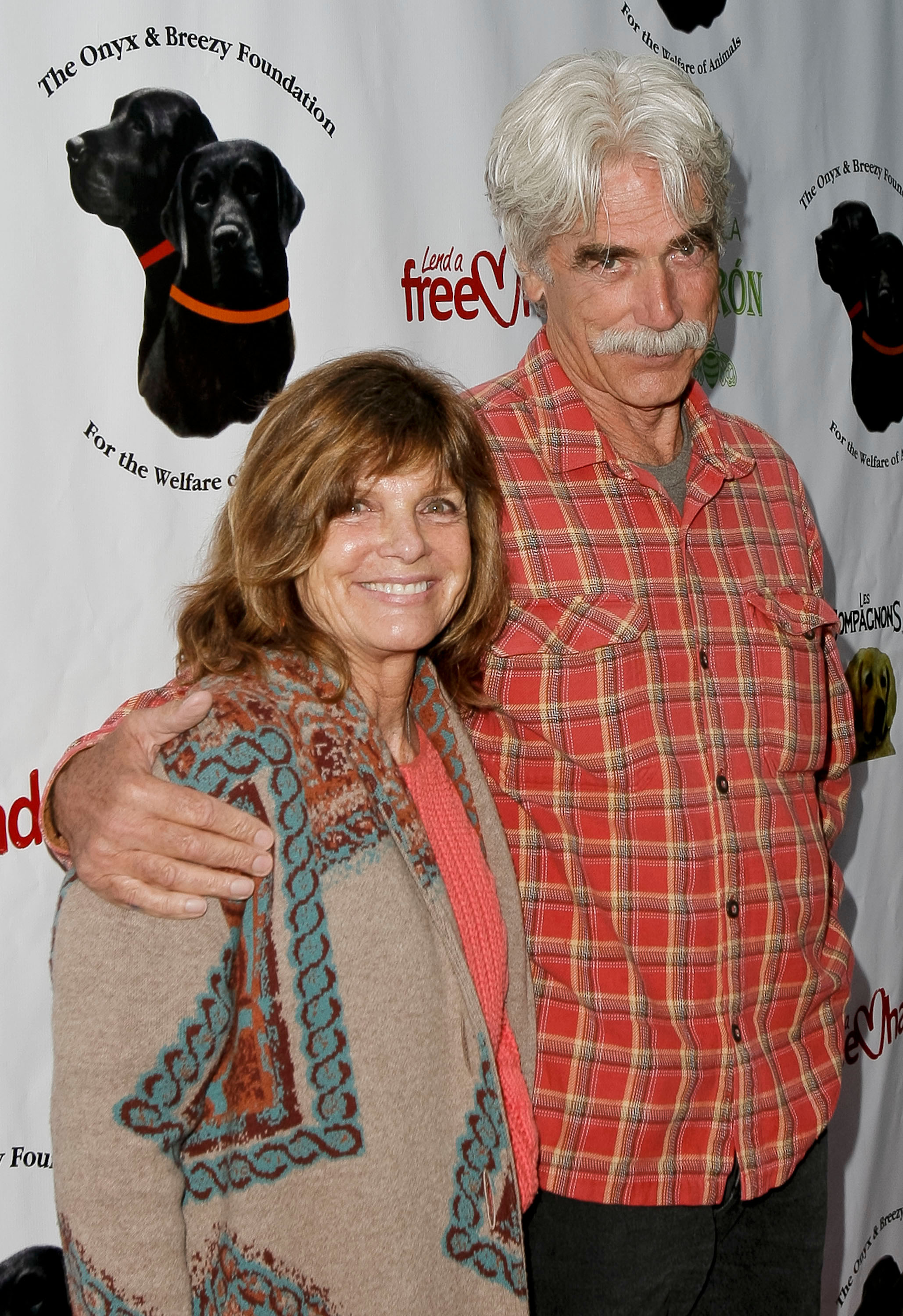 Katharine Ross and Sam Elliott kept things cozy and casual at the Onyx & Breezy Foundation's "Saving Tails" gala on April 13, 2013, in Hollywood, California. Sam wrapped an arm around Katharine wearing a red-and-yellow plaid button-down shirt, while she smiled warmly in a coral top layered under a patterned southwestern-style cardigan. | Source: Getty Images