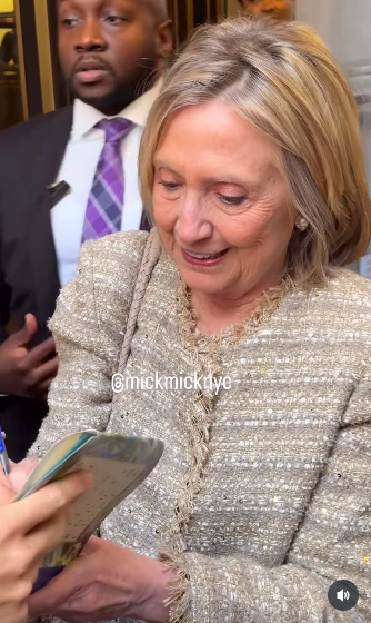 Former U.S. First Lady Hillary Clinton signing a book for a fan, posted on June 6, 2025. | Source: Instagram/mickmicknyc