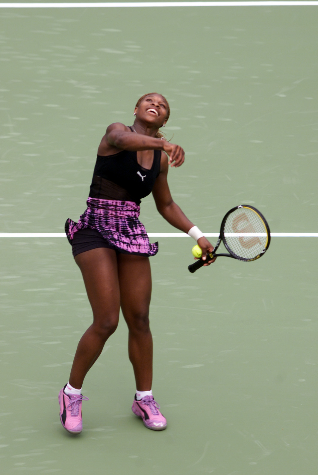 Serena Williams celebrates after defeating Lilia Osterloh in the first round of the Adidas International Tennis Tournament at the Sydney International Tennis Centre in Homebush, Australia. Her athletic attire accentuates her powerful legs as she leaps into the air in triumph.