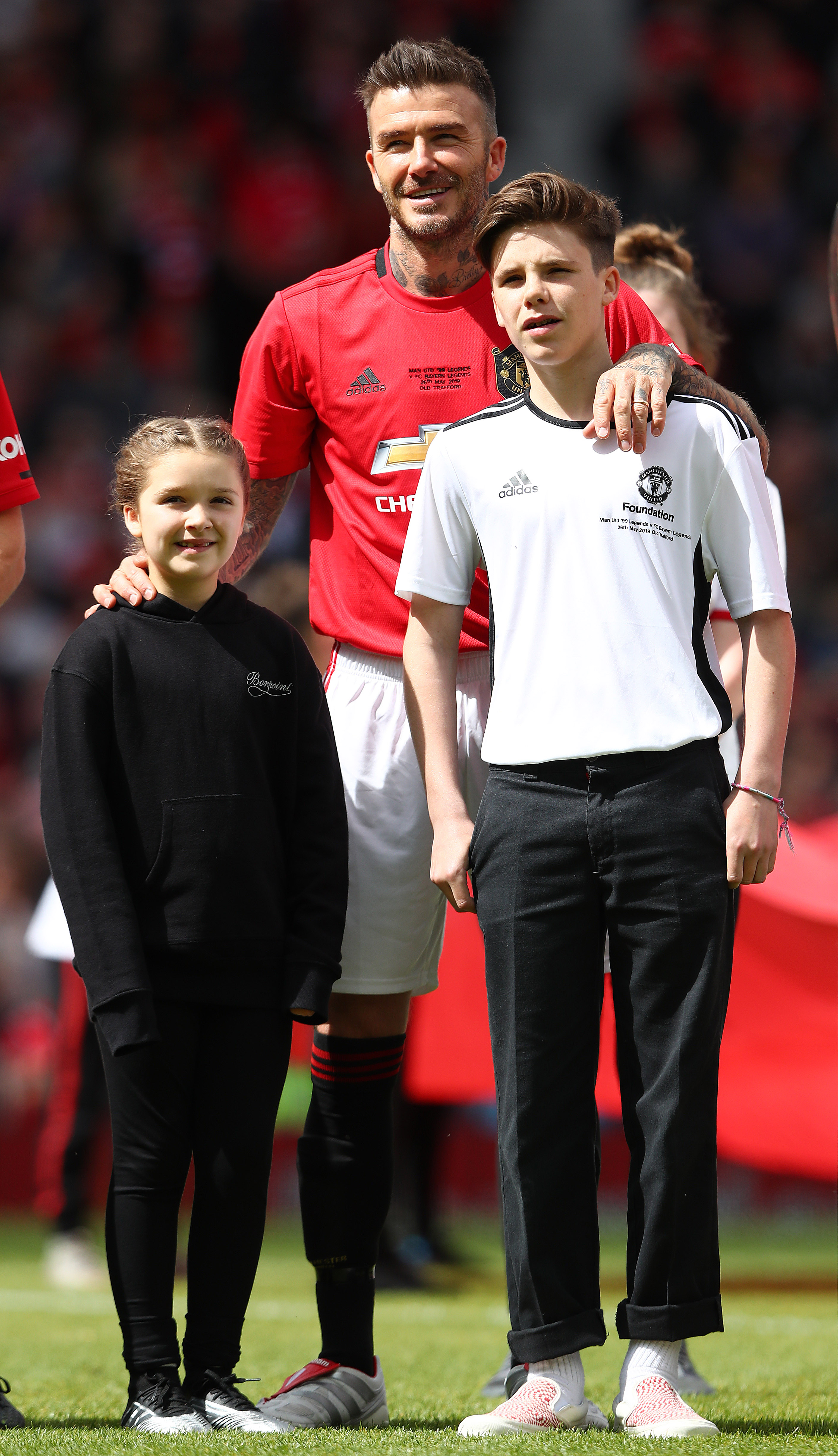 David Beckham poses with his son Cruz and daughter Harper at Old Trafford in 2019, when he returned to the pitch for a Manchester United charity match. | Source: Getty Images.