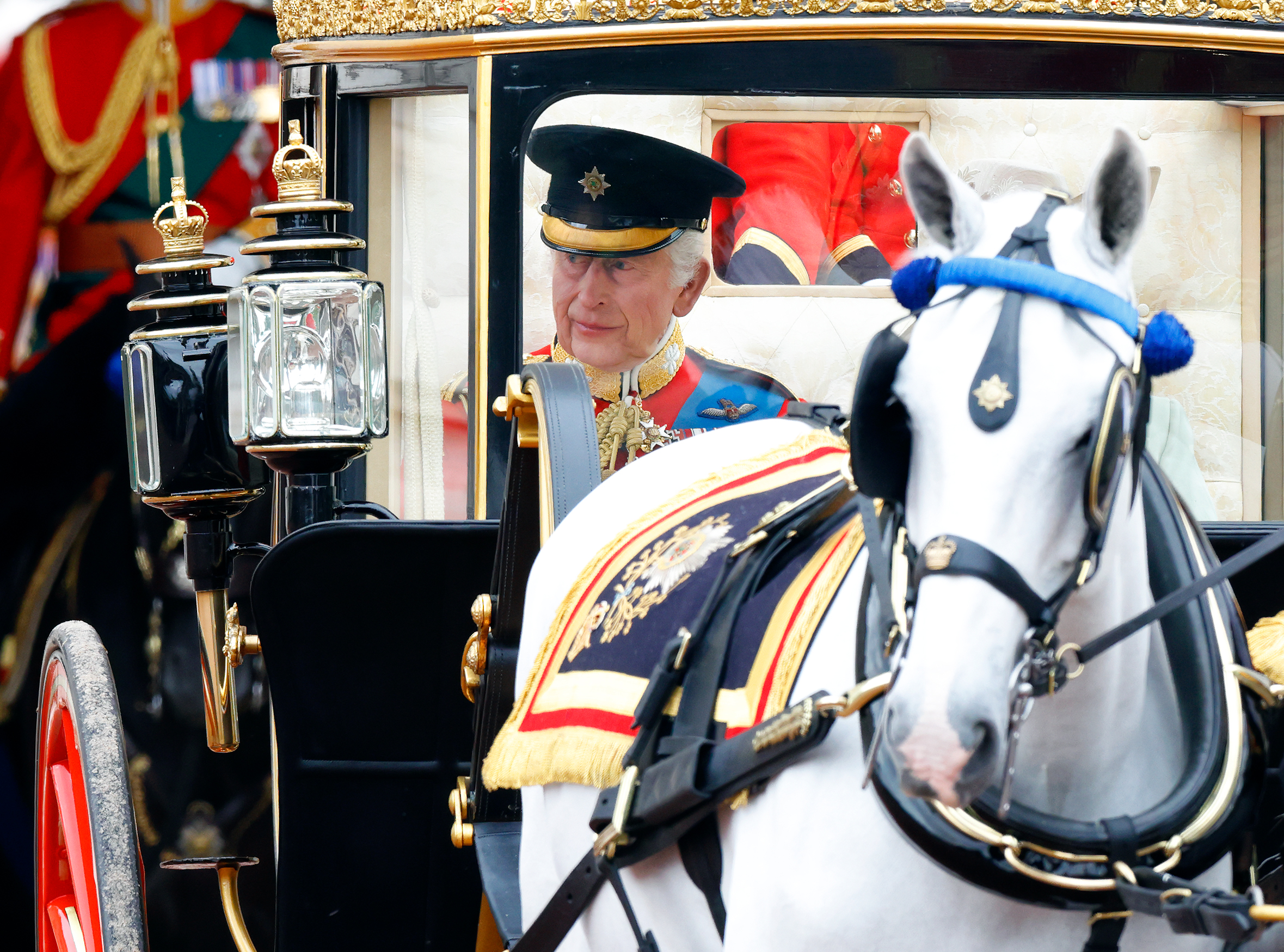 King Charles III appears solemn and composed in his Irish Guards uniform as he rides in the State Coach to Trooping the Colour 2024 | Source: Getty Images