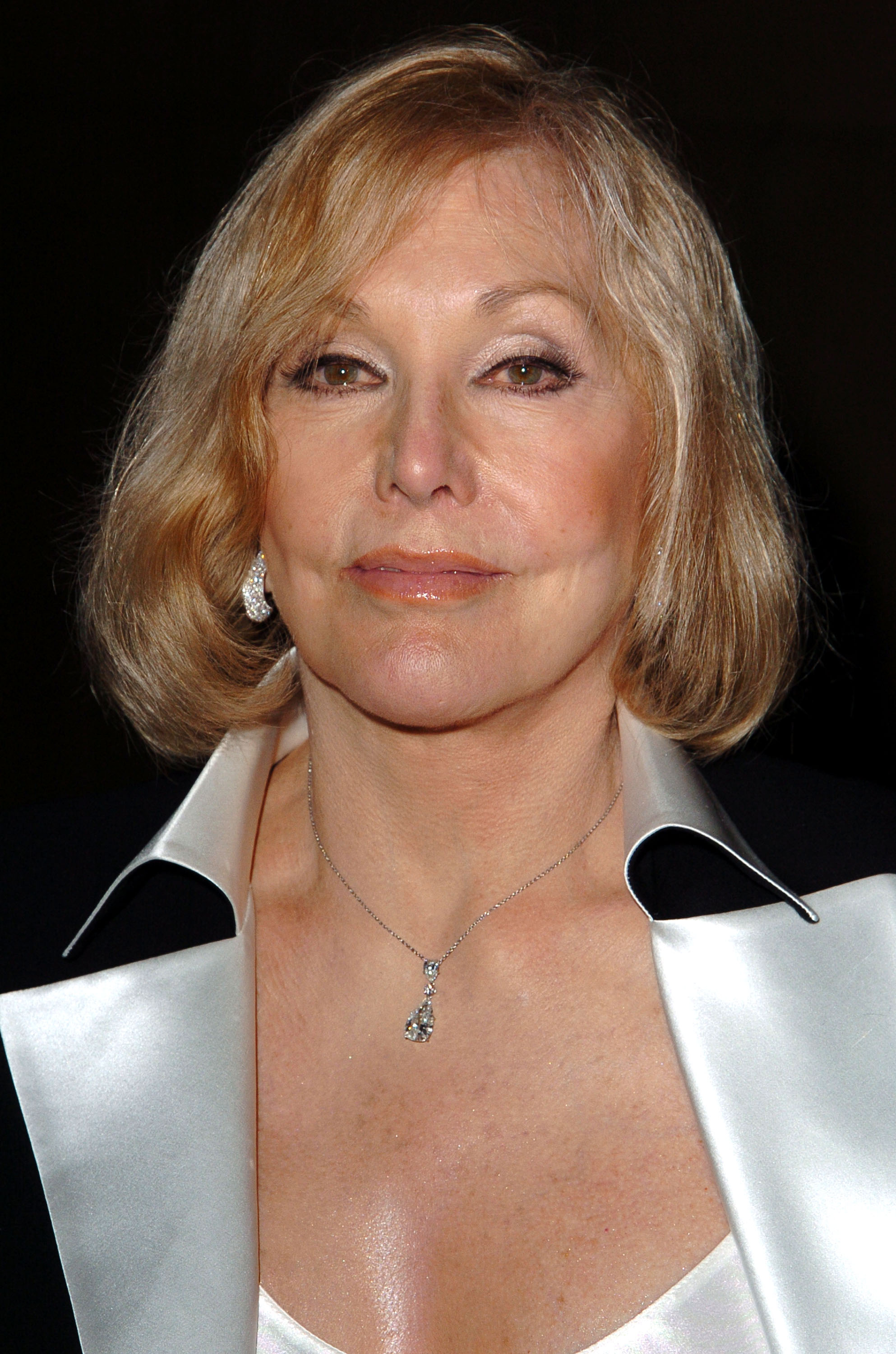Kim Novak attends a Vertigo screening at the Egyptian Theatre in Hollywood, wearing a white satin outfit with a contrasting black collar and a pendant necklace. | Source: Getty Images