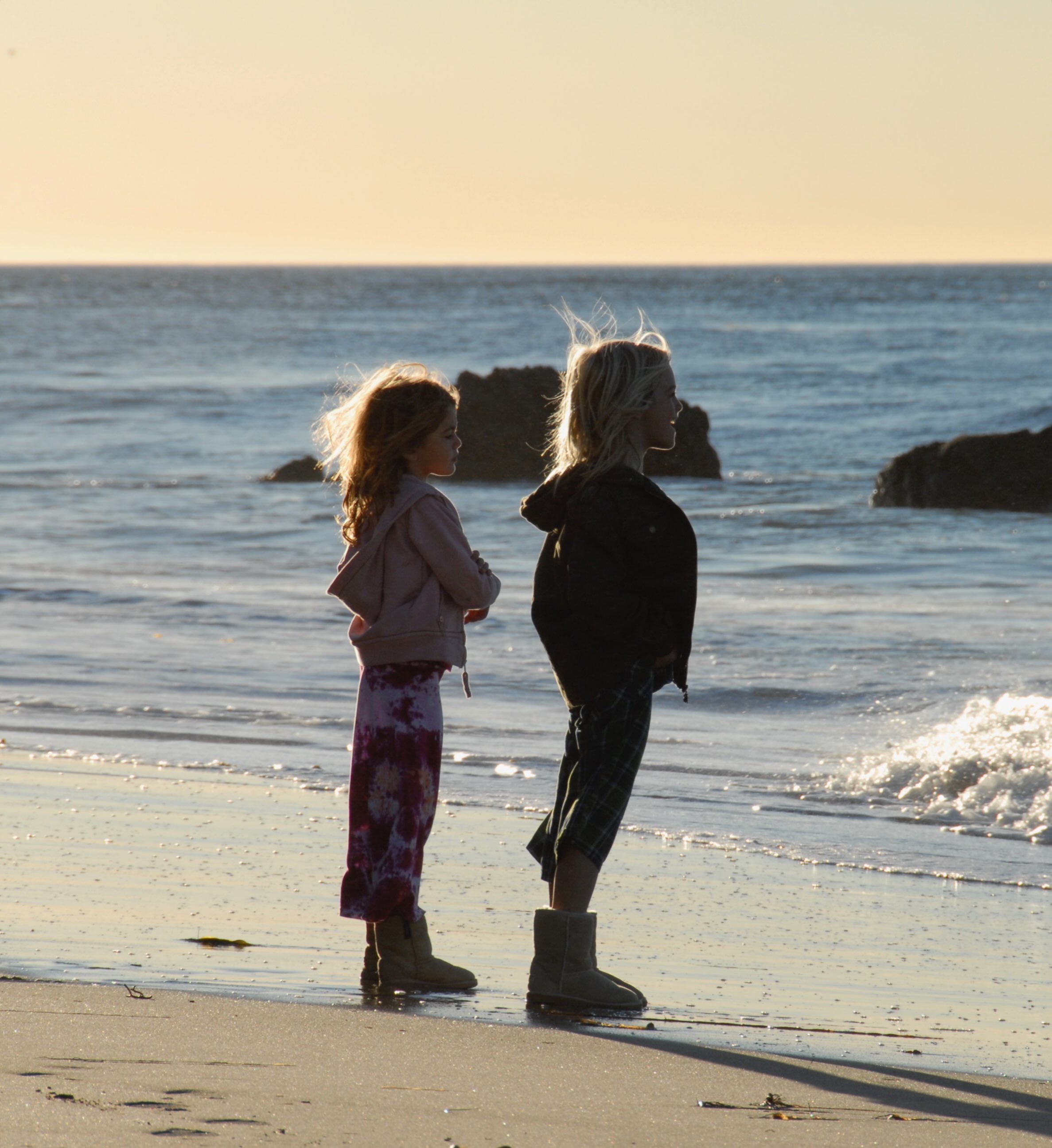A young Kaia Gerber stands beside her older brother, Presley, at the water's edge in a childhood beach photograph included in her October 2026 tribute carousel. | Source: Instagram/kaiagerber