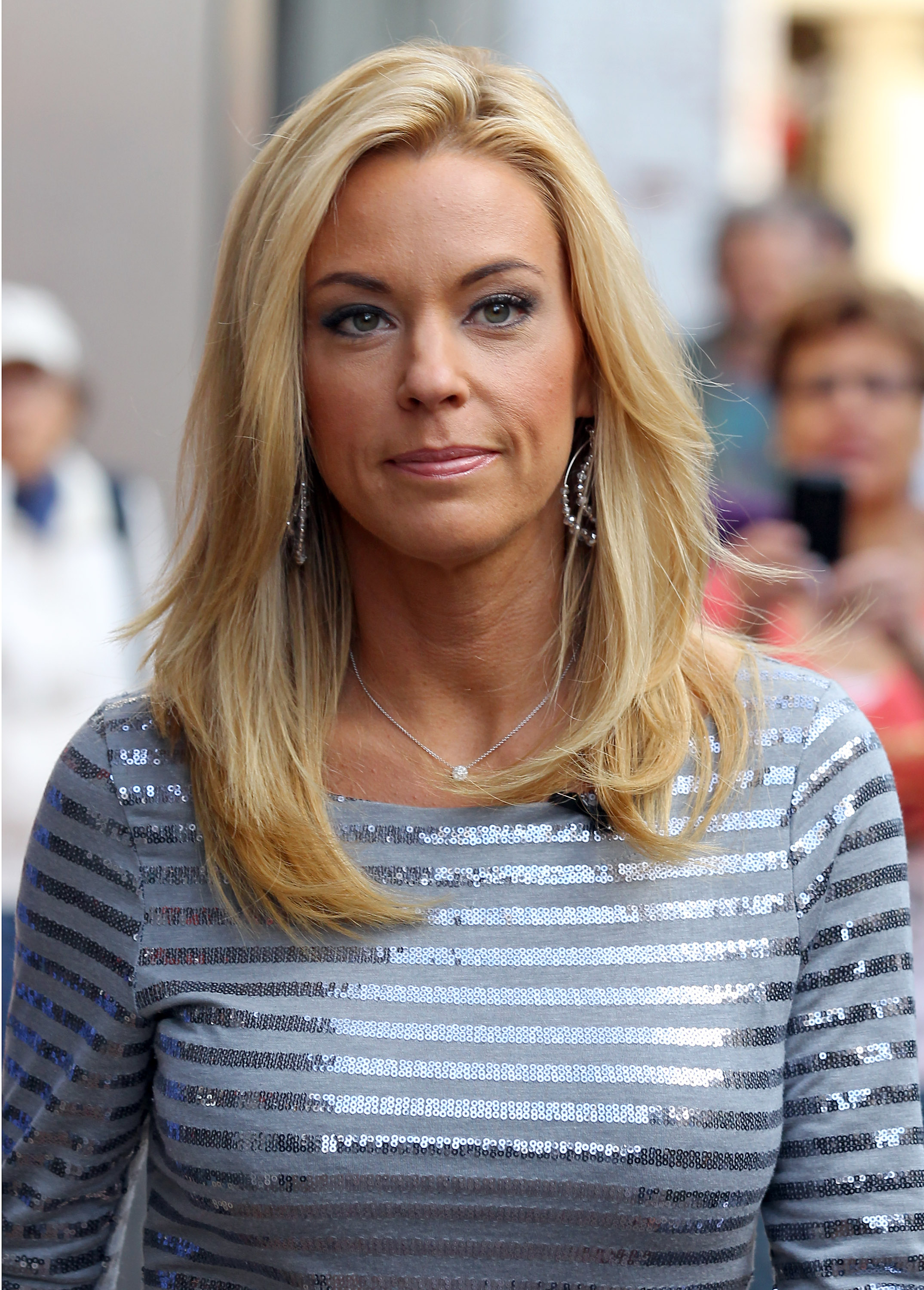 Spotted in Los Angeles, Kate Gosselin wears a silver-striped top with subtle shimmer. Her layered blonde hair, round earrings, and simple necklace give her a sleek style as she walks with a serious yet composed expression.