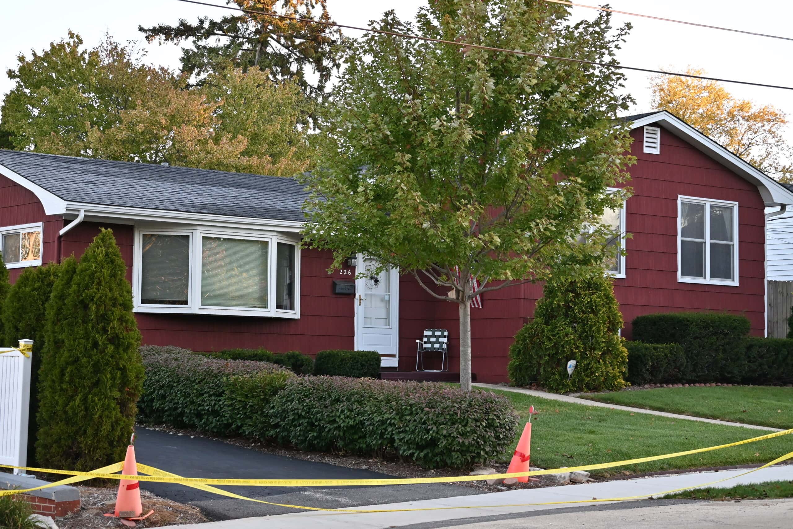 The Schmidt family home at 226 Wellington Avenue, where a small American flag and a folding chair remained beside the front door as police secured the driveway during their investigation. | Source: Joe Lewnard / Daily Herald.
