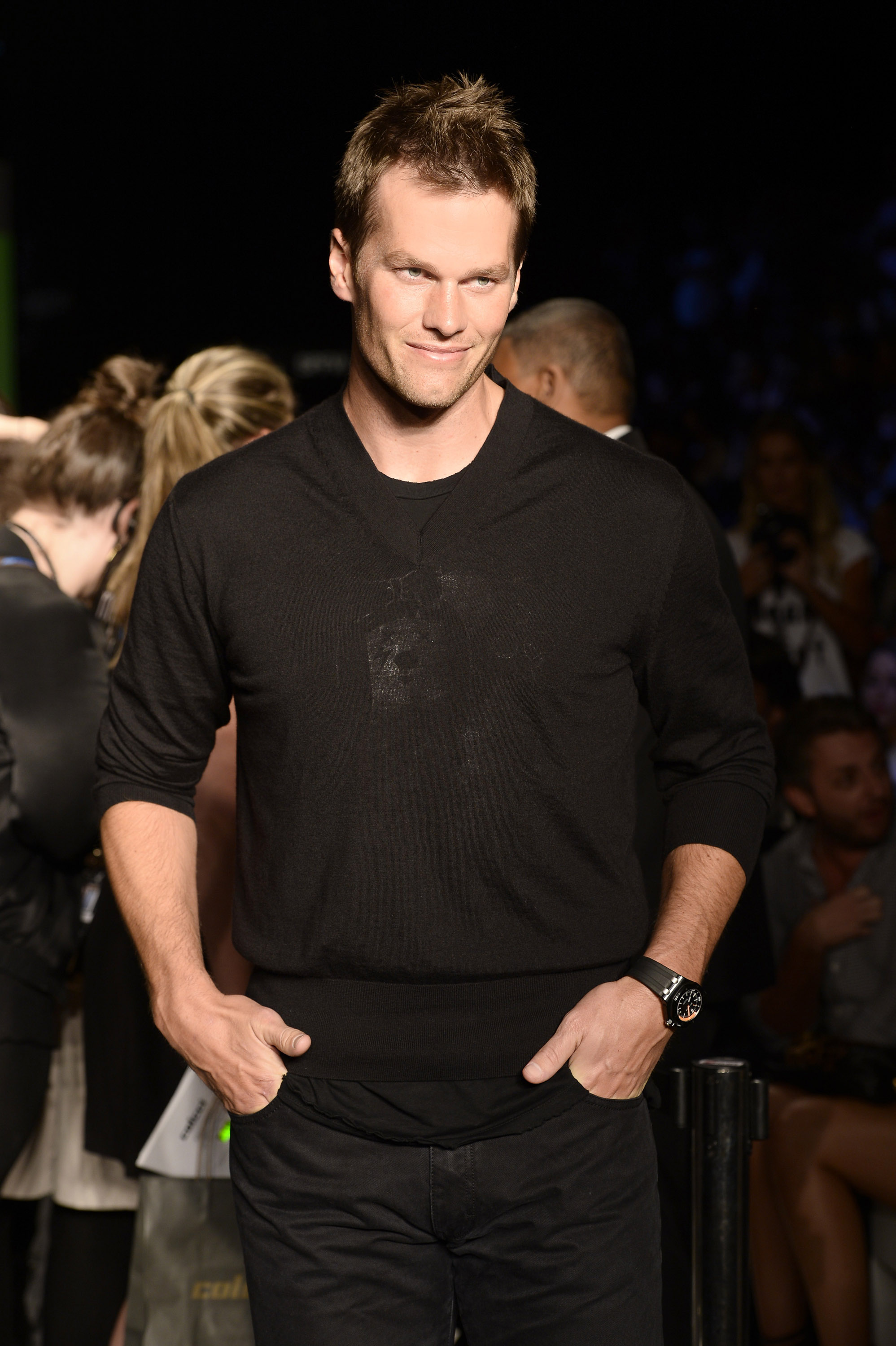 Tom Brady, with his chiseled, model-like features, attends the Colcci runway show at São Paulo Fashion Week Summer at Parque Cândido Portinari in Brazil. Dressed in an all-black outfit with hands casually in his pockets and a watch gleaming on his left wrist, he exudes effortless cool.
