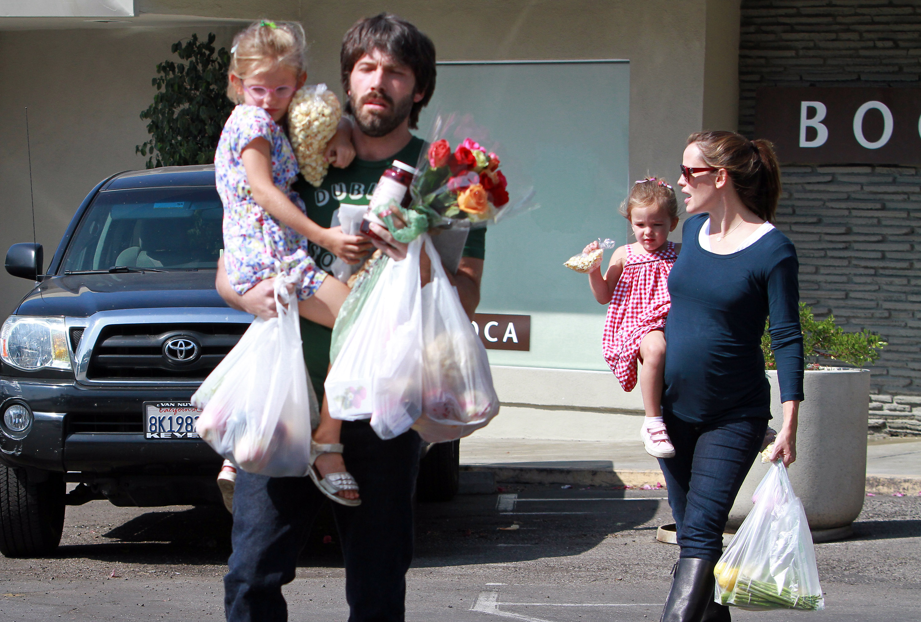 Ben Affleck and Jennifer Garner juggle groceries, flowers, and two of their children during a family outing in Los Angeles in 2011. Years later, fans wondered whether Jennifer's Father's Day tribute quietly recognized the father Ben has continued to be to their children. | Source: Getty Images