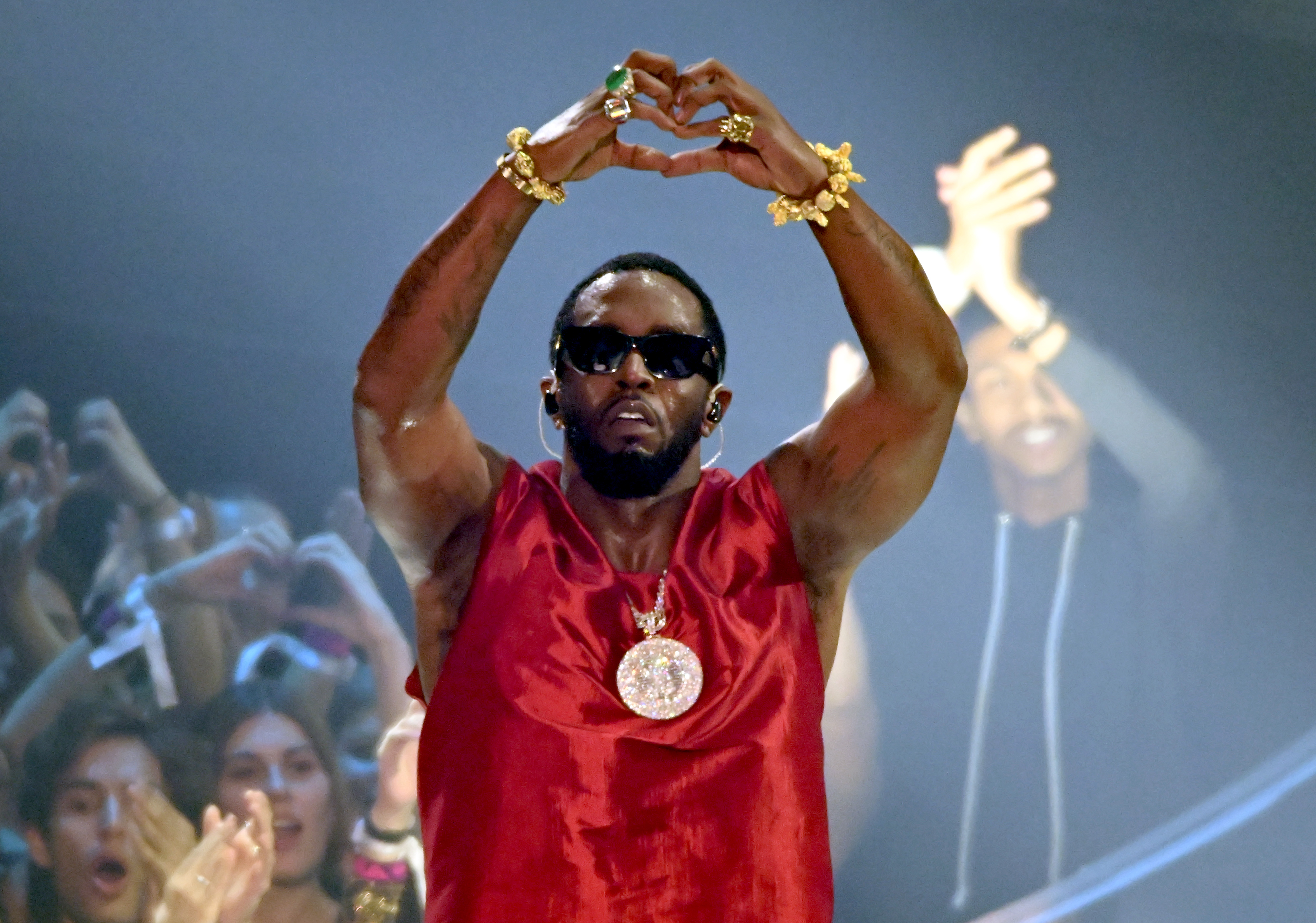Sean "Diddy" Combs raises his arms to form a heart shape over his head while performing on stage at the MTV Video Music Awards in Newark, New Jersey, on September 12, 2023.