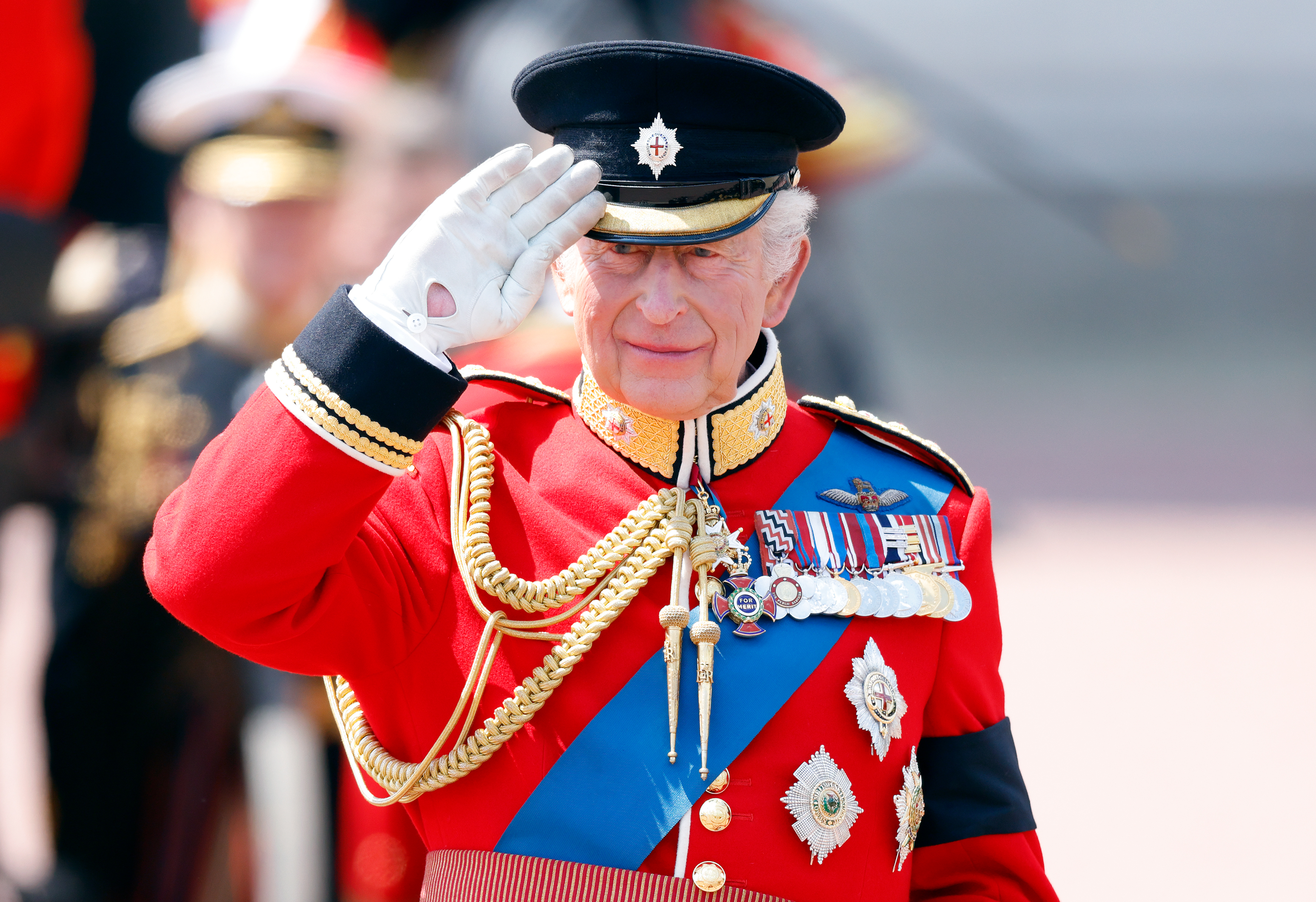 King Charles III takes the salute from a dais outside Buckingham Palace during Trooping the Colour 2025 | Source: Getty Images