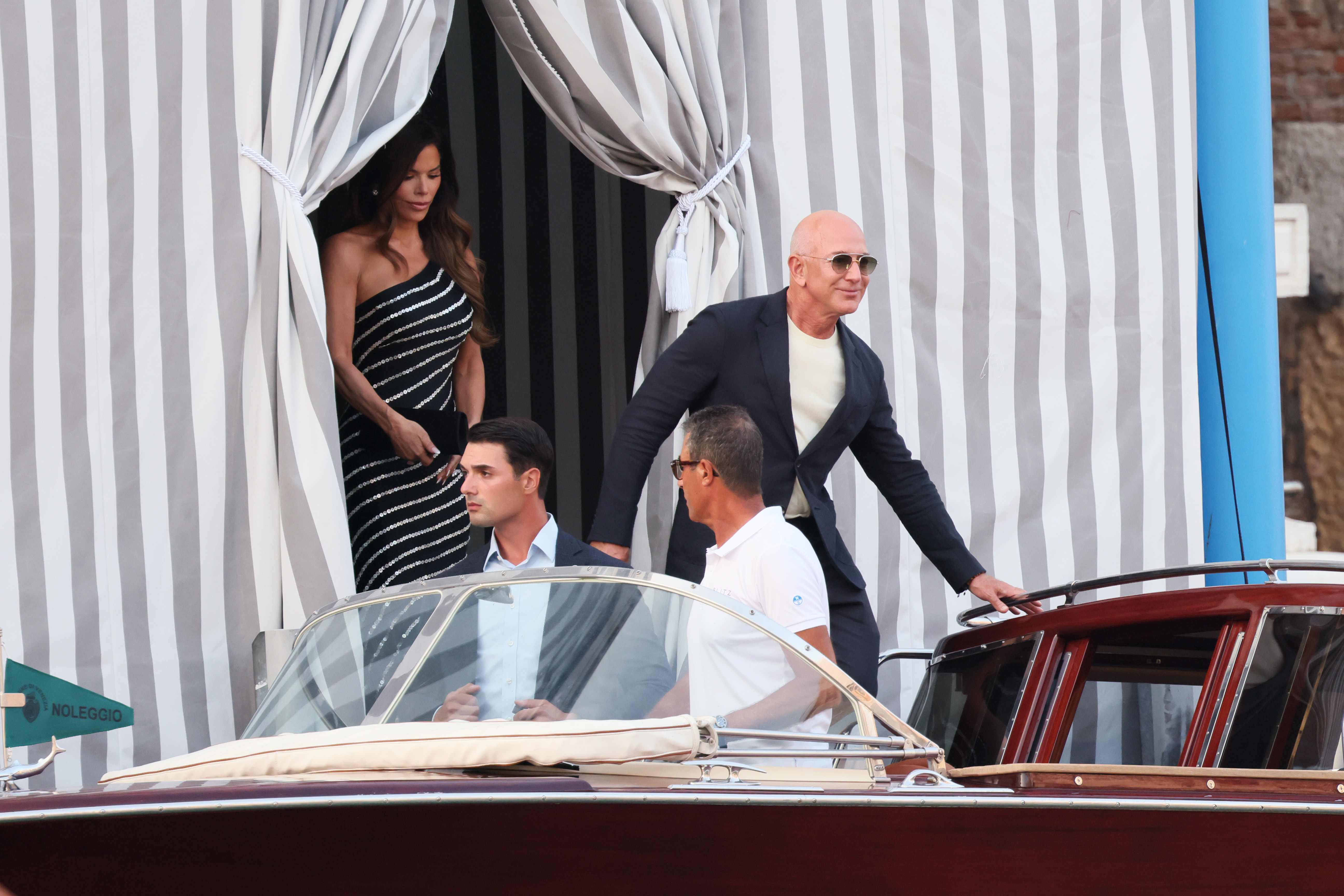 Jeff Bezos steps toward a waiting boat as Lauren Sanchez appears behind him at their Venice hotel on June 25, 2025, ahead of their wedding weekend | Source: Getty Images