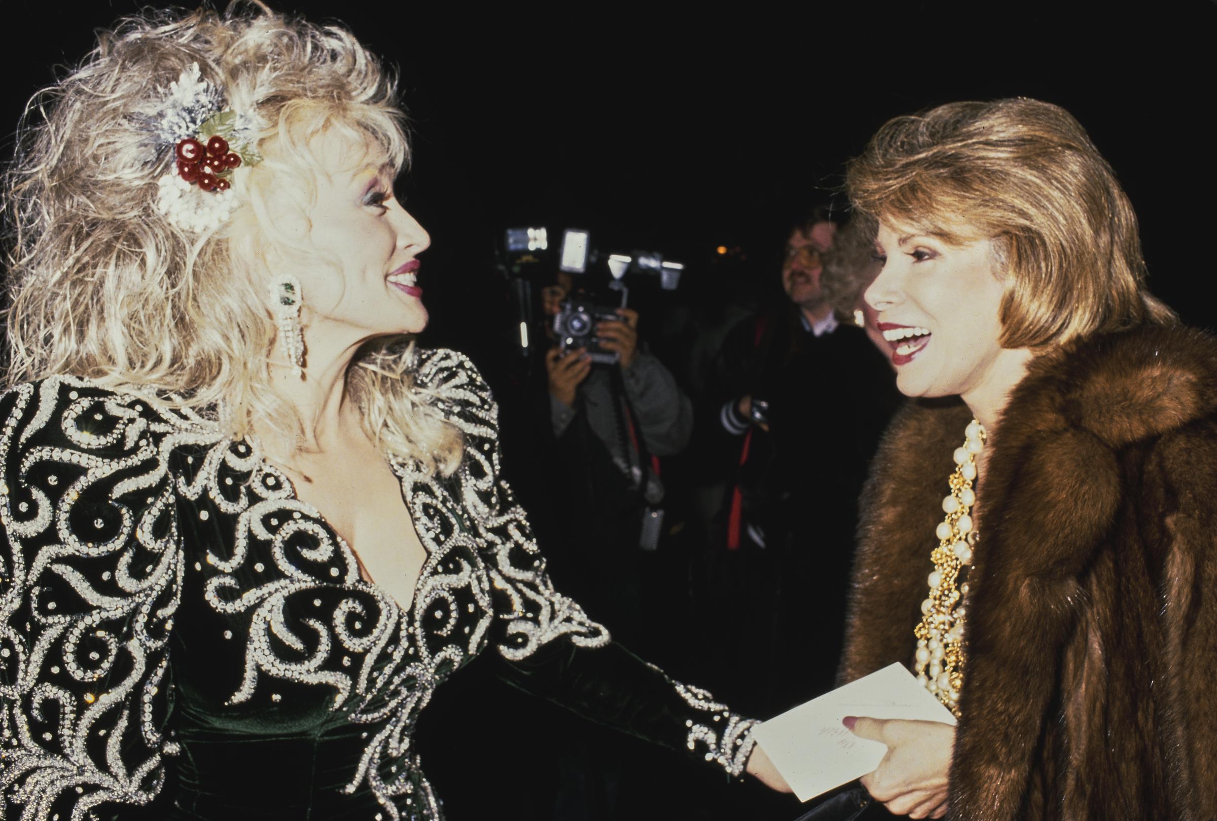 Dolly Parton and Joan Rivers attend Sandy Gallin’s Christmas party at his home in Beverly Hills, California, on December 18, 1988. | Source: Getty Images