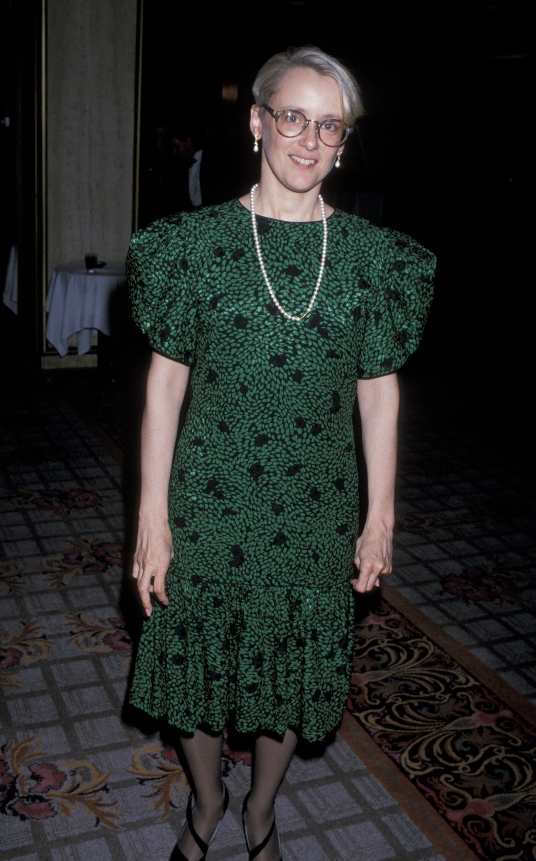 Mary Beth Hurt poses at the 4th Annual Moving Picture Ball in Los Angeles in 1989. Wearing glasses, pearls, and a green patterned dress with puffed sleeves, Hurt looks polished and confident at the star-studded charity event.