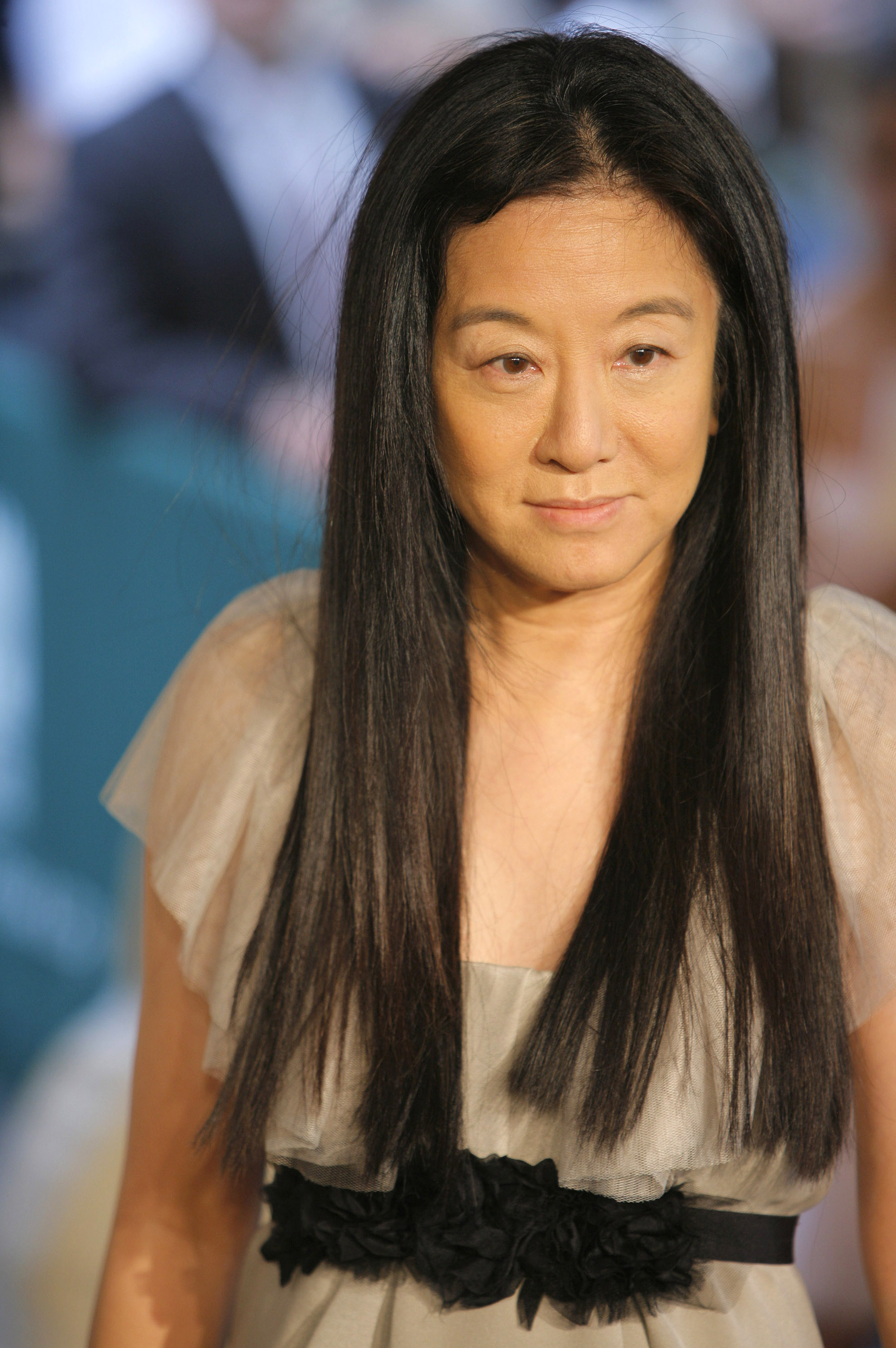Fashion designer Vera Wang posed on the red carpet during arrivals at the 2006 CFDA Awards in New York City. She donned an ethereal, muted taupe gown accented with fluttery tulle cap sleeves and a contrasting black floral rosette waistband, keeping her signature raven hair pin-straight and parted down the middle. | Source: Getty Images