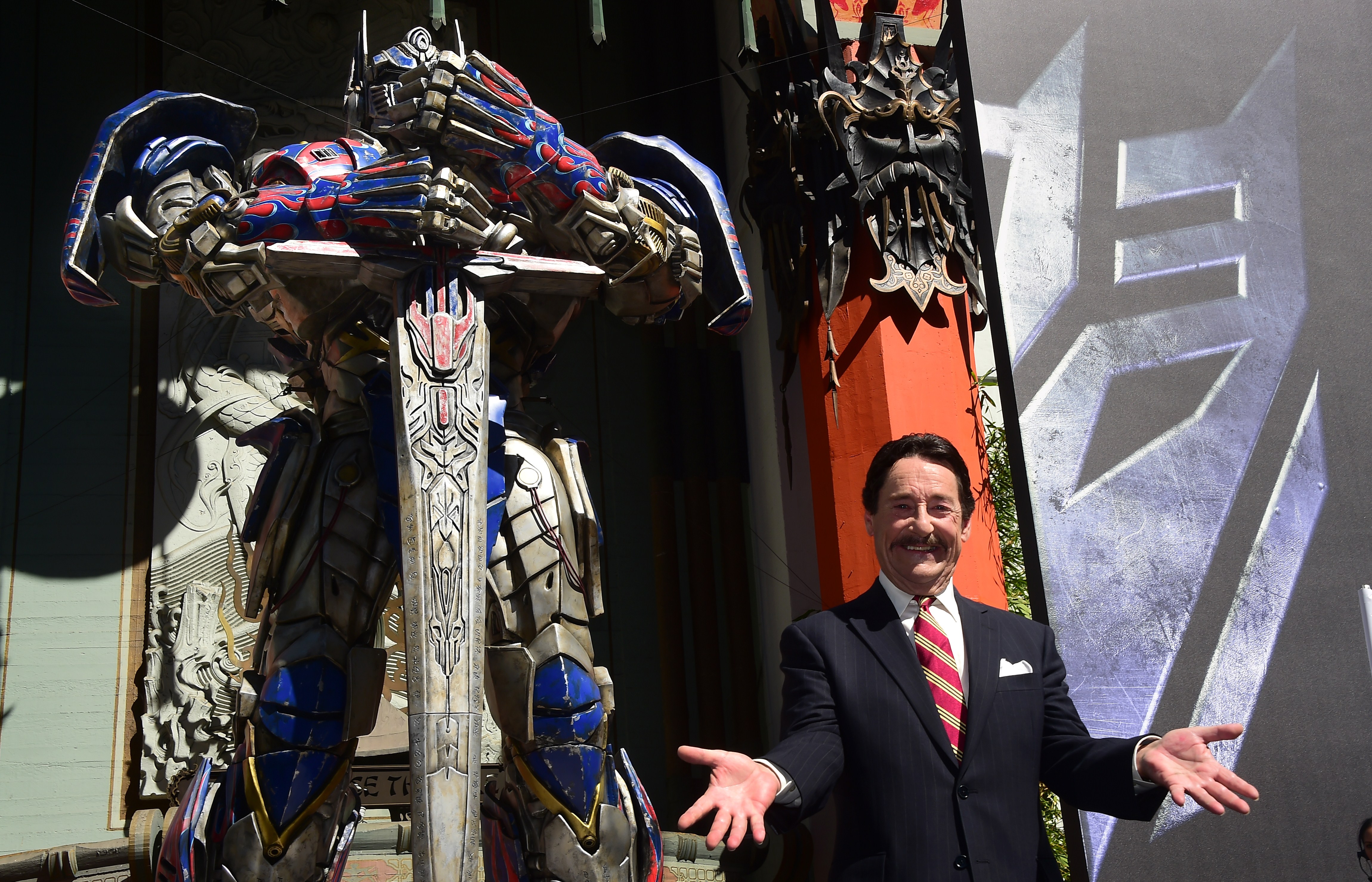 Peter Cullen joins Optimus Prime at a 2014 handprint ceremony outside the TCL Chinese Theatre in Hollywood, where the character was honored with a tradition usually reserved for Hollywood stars. The tribute underscored how closely Cullen had become linked to the Autobot leader after voicing him across the Transformers franchise. | Source: Getty Images