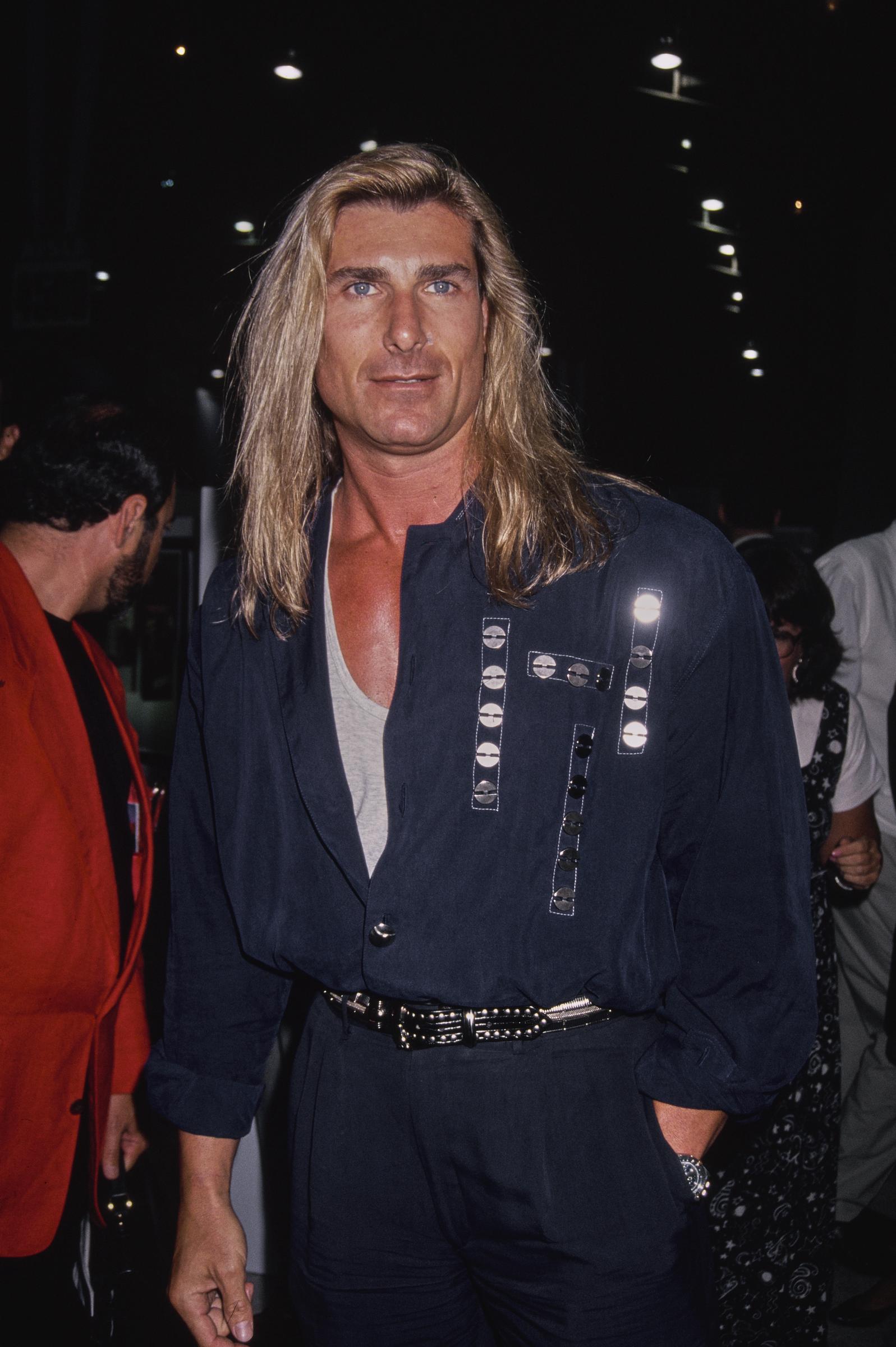 He walked out of that meeting with a lucrative contract in hand. In this photo, the iconic romance book cover star attended the "Pauly Does Dallas" premiere after party at the Comedy Store in Los Angeles, California, on August 26, 1992. | Source: Getty Images