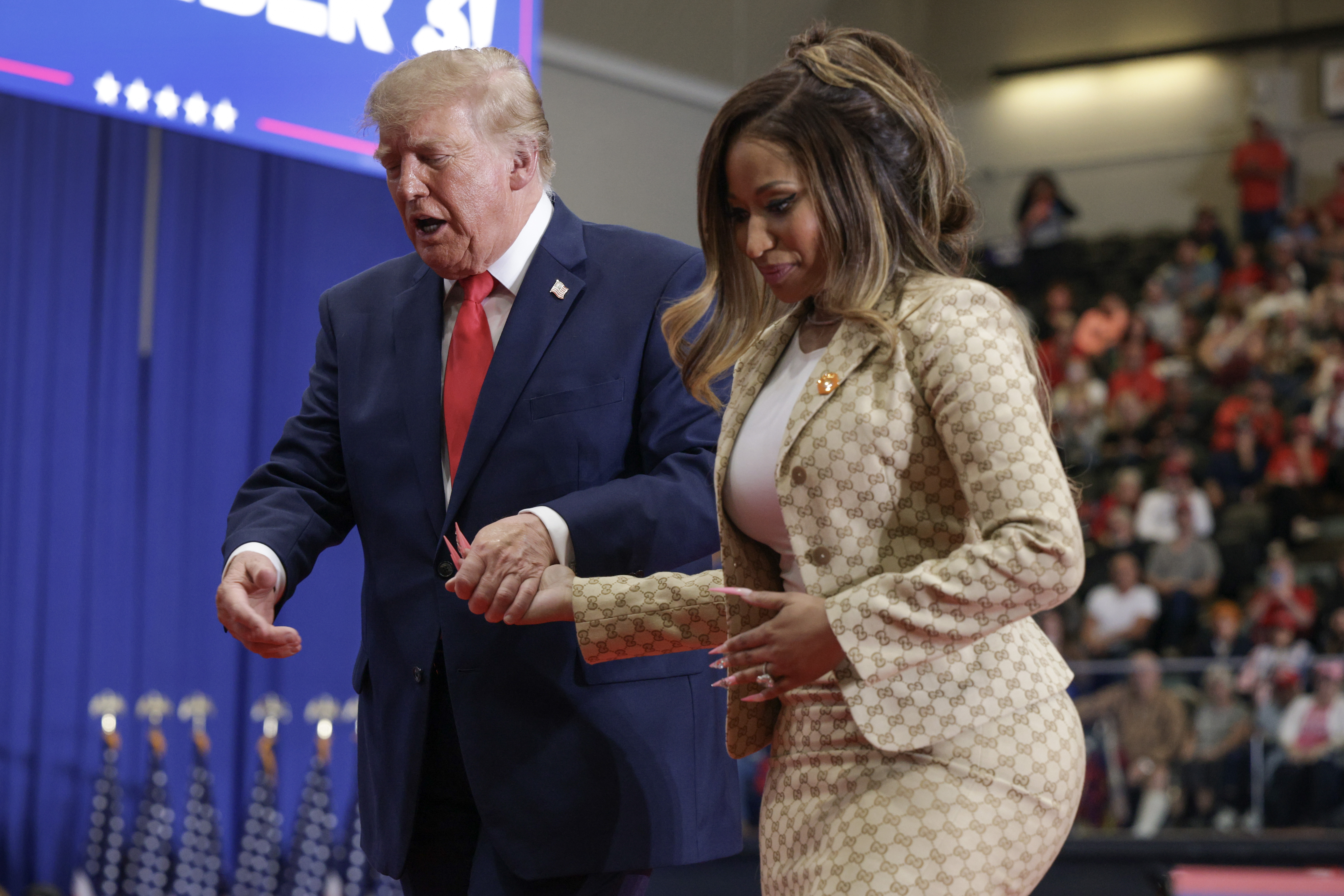 Donald Trump holds Nicki Minaj's hand as they walk across the stage, gesturing ahead with his free hand — a moment that prompted viewers to make cheeky comparisons involving Melania Trump. | Source: Getty Images