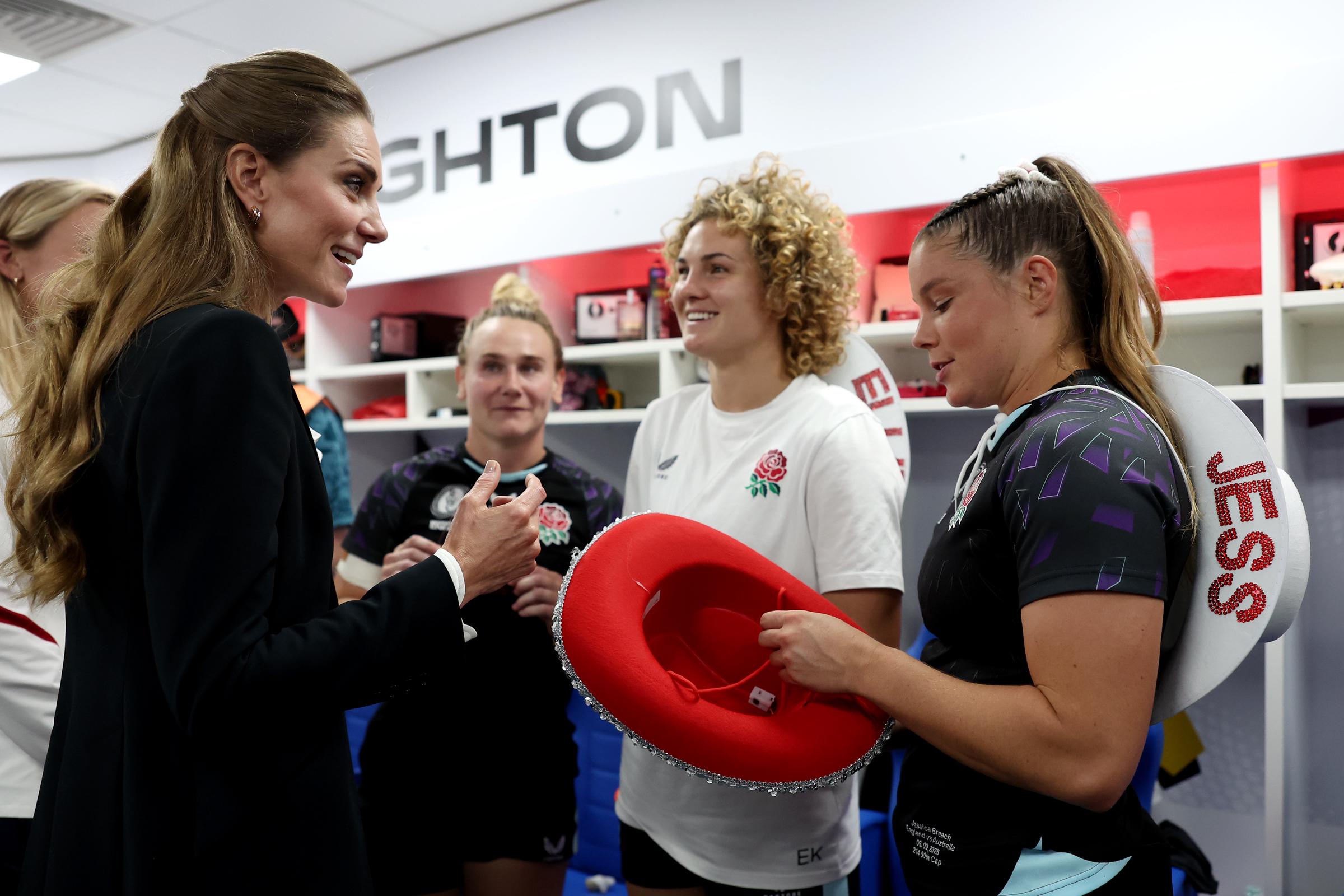 Princess Catherine speaking with some Red Roses players in a locker room as they present her with the cowboy hat during the Women's Rugby World Cup 2025 Pool A match in Brighton, England on September 6. | Source: Getty Images
