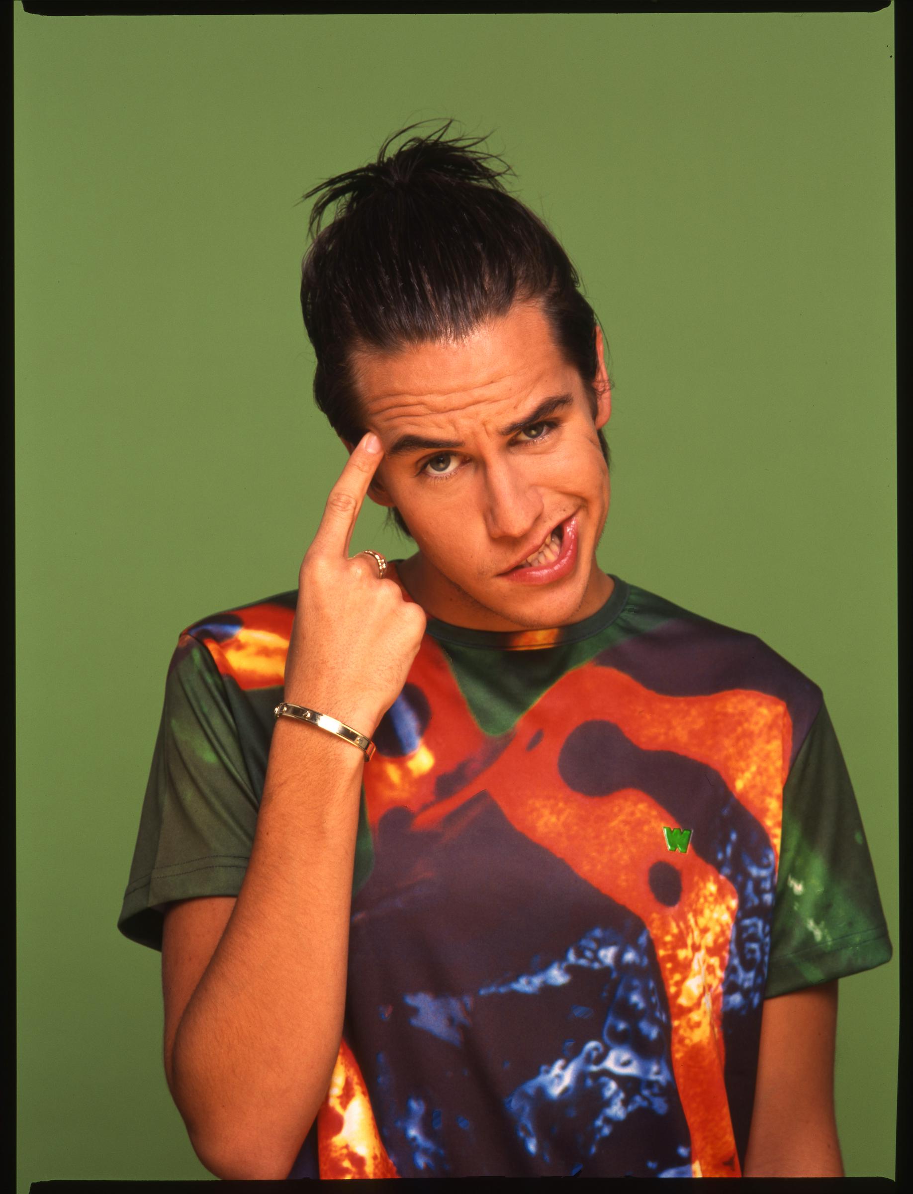 The pop singer in the United Kingdom, hair tied back in a ponytail, strikes a goofy pose. With his teen years behind him, he still exudes a sense of fun and playfulness that shines through in the moment.