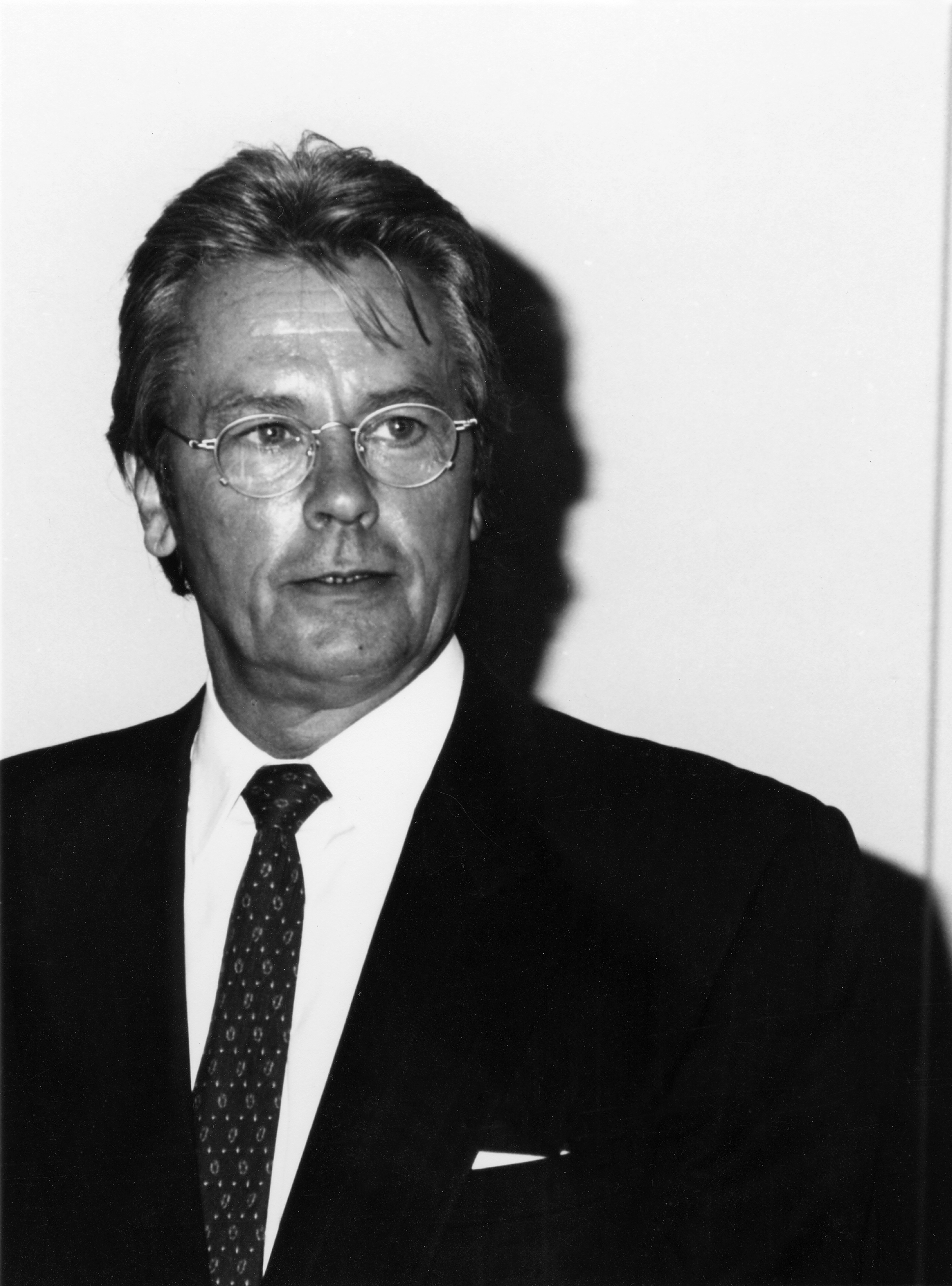 Alain Delon in a portrait taken in 1994, wearing a suit and tie with a composed expression | Source: Getty Images
