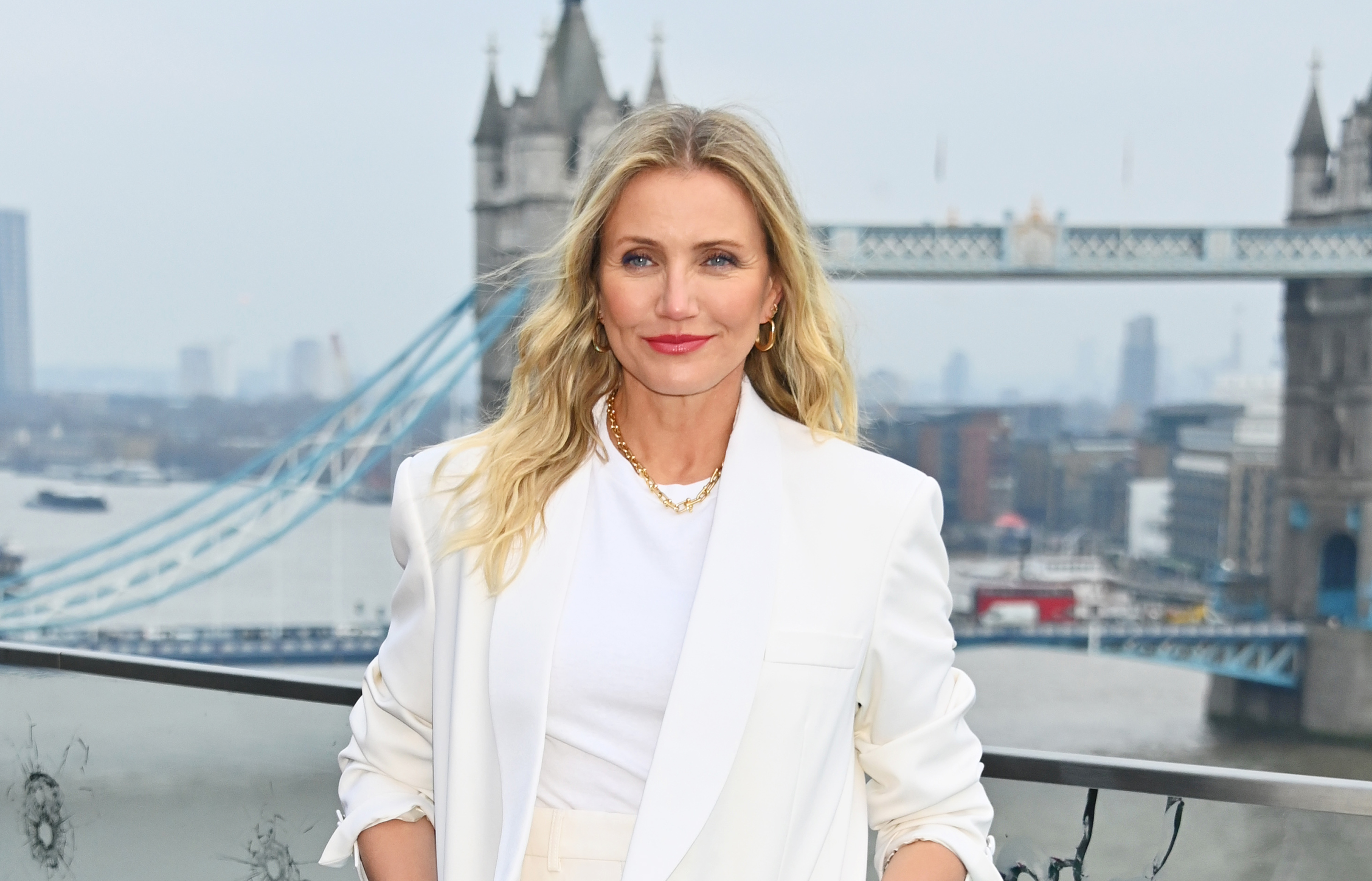 On January 17, Cameron Diaz posed at the London photocall for "Back In Action" at Cheval Three Quays, with the iconic Tower Bridge as her backdrop. Wearing a crisp white suit with her hair styled longer and in a lighter blonde shade, the actress radiated poise as she returned to the film world after years focused on family life with Benji Madden and their children.