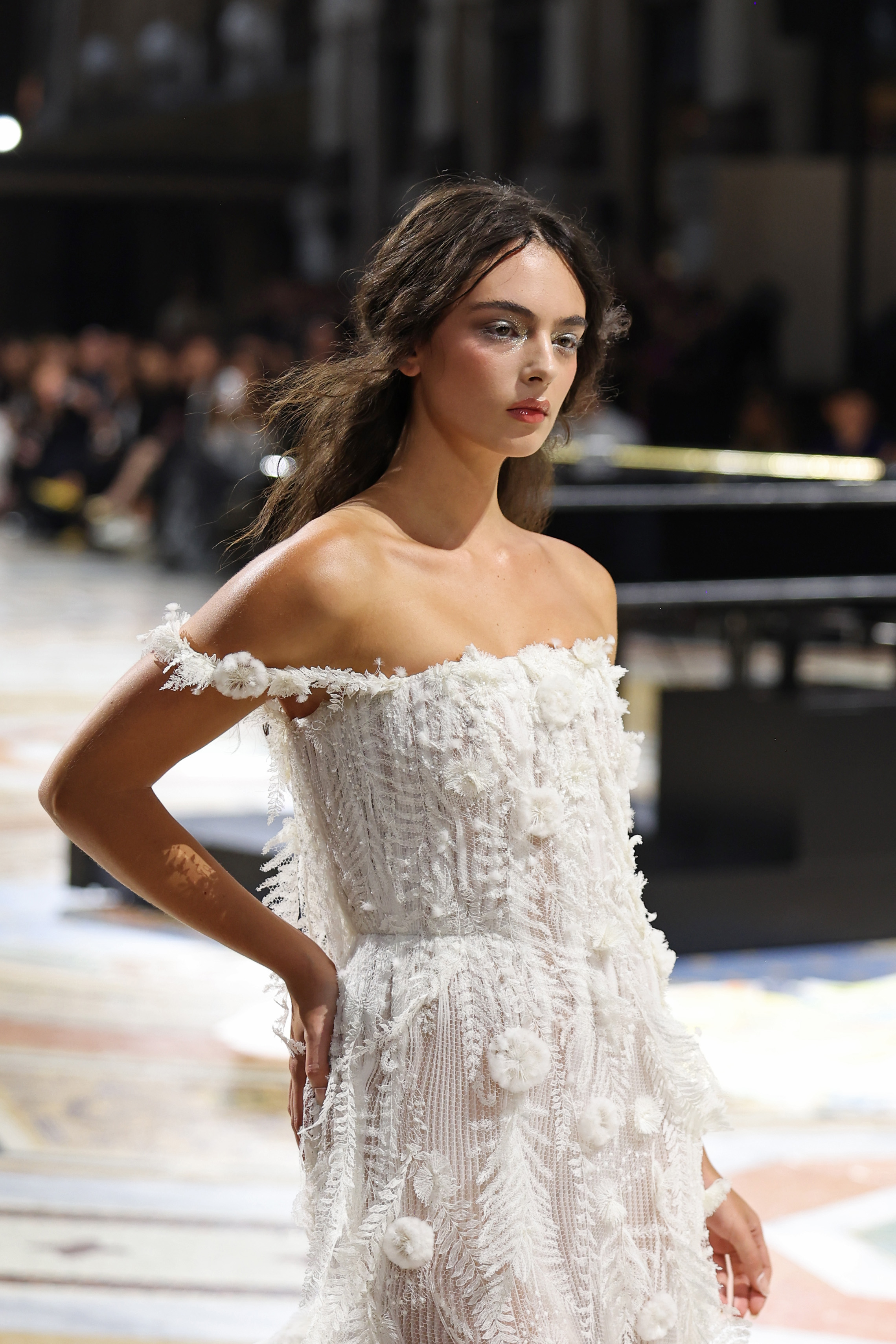Deva Cassel radiated bridal elegance as she took to the runway for Vogue World: Milano 2026 on September 22, 2026, in Milan, Italy. A close portrait highlighted her romantic beauty look, featuring shimmery silver eye makeup, glowing rosy cheeks, and loose brunette waves, complemented by the delicate, off-the-shoulder floral embroidery of her ivory gown. | Source: Getty Images