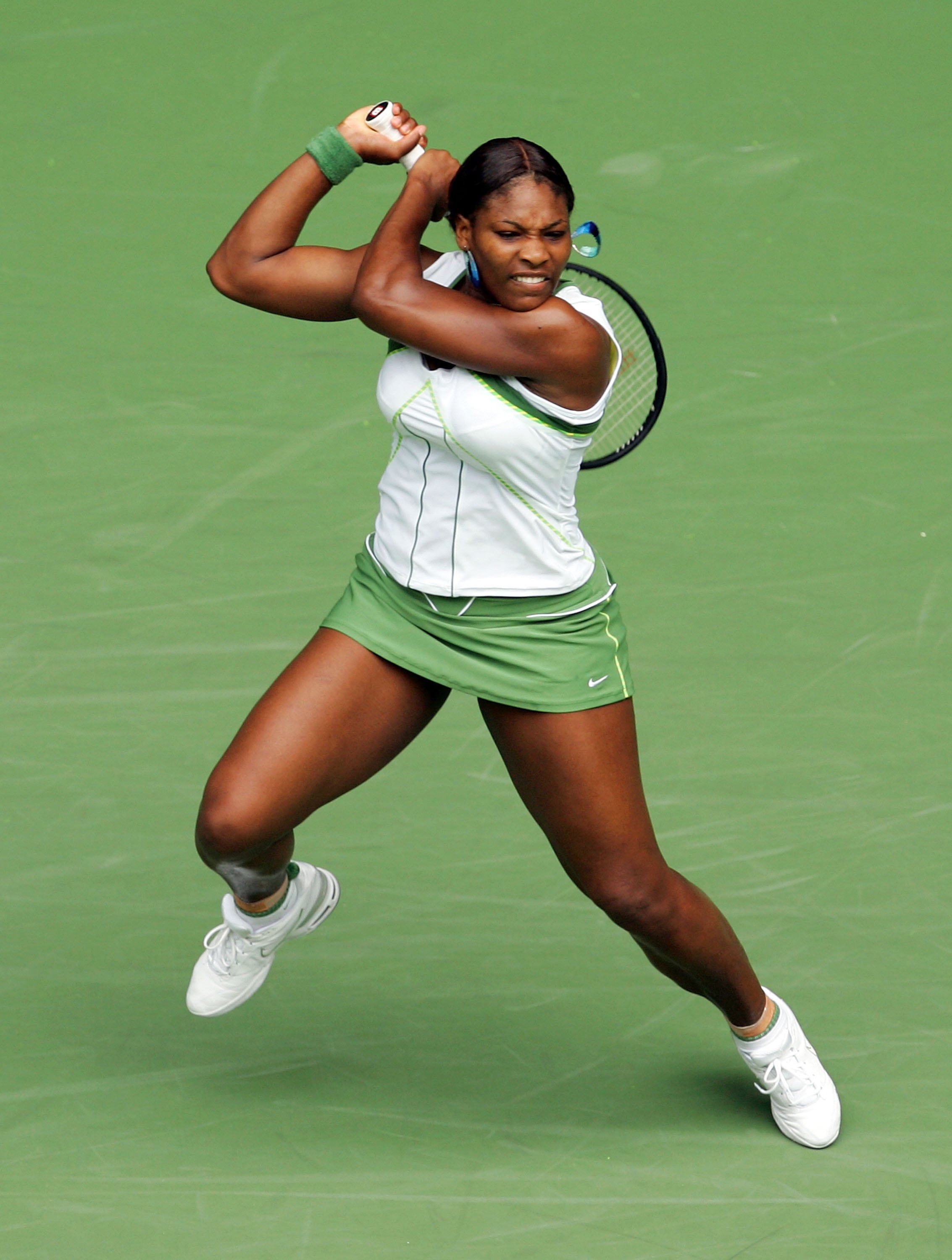 Back on the court, Serena Williams is captured mid-action, executing a backhand with focused intensity, biting her lower lip during her second-round match against Anne Kremer on day three of the Australian Open at Melbourne Park in Melbourne, Australia.