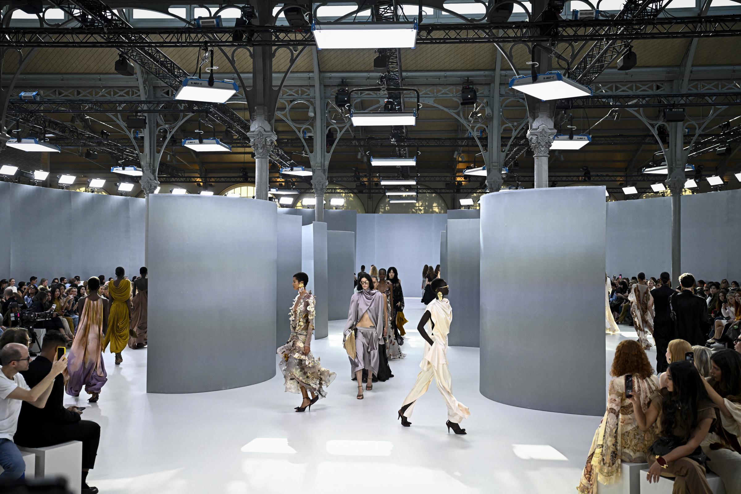 Models walk through the Zimmermann Spring/Summer 2027 presentation in Paris, where curved gray structures formed the runway setting. The show was part of the womenswear schedule during Paris Fashion Week.