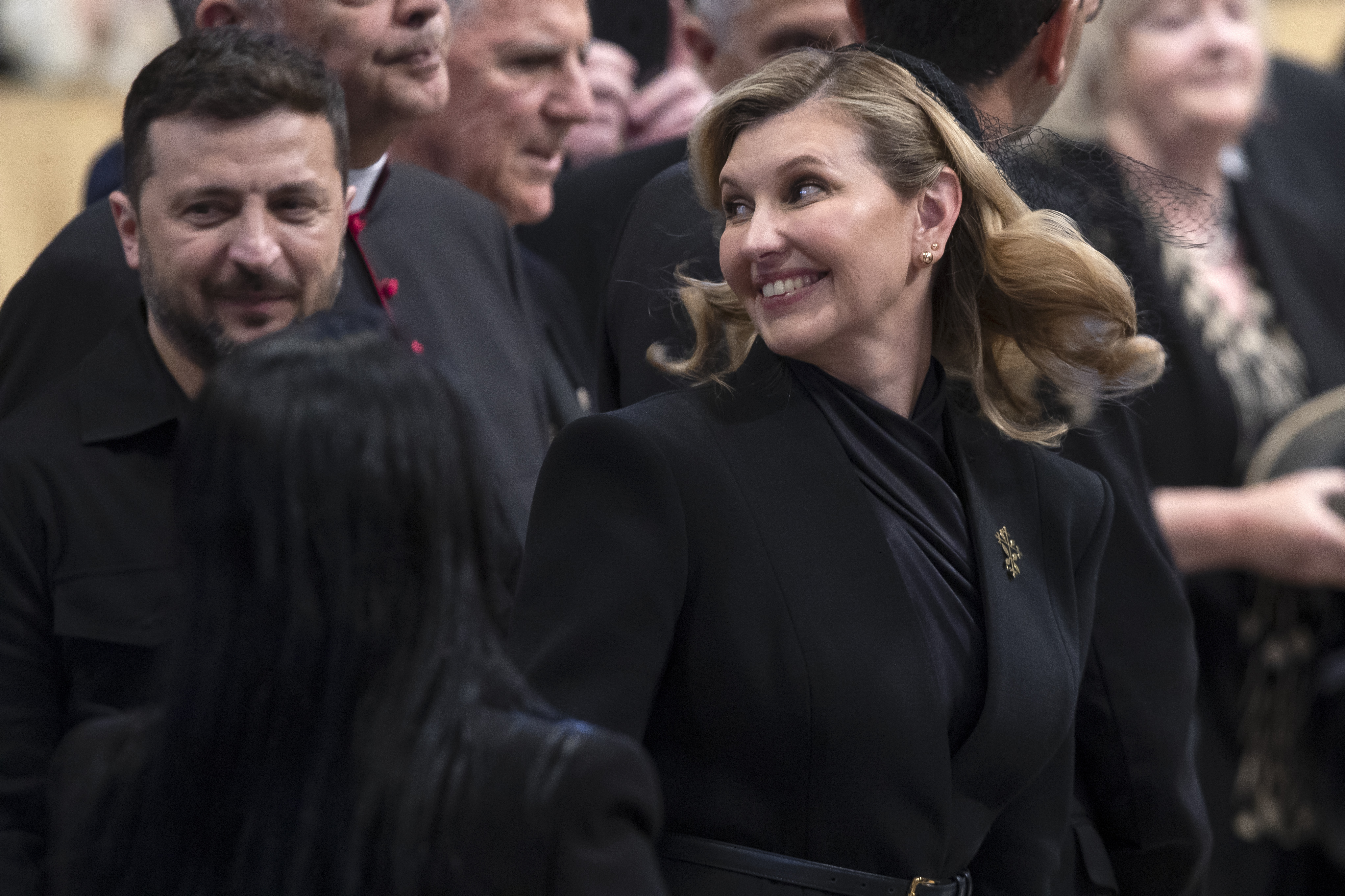 Ukrainian President Volodymyr Zelenskyy and First Lady Olena Zelenska smile warmly while attending the holy mass for the inauguration of Pope Leo XIV at St. Peter's Square in Vatican City on May 18, 2025, among global dignitaries.